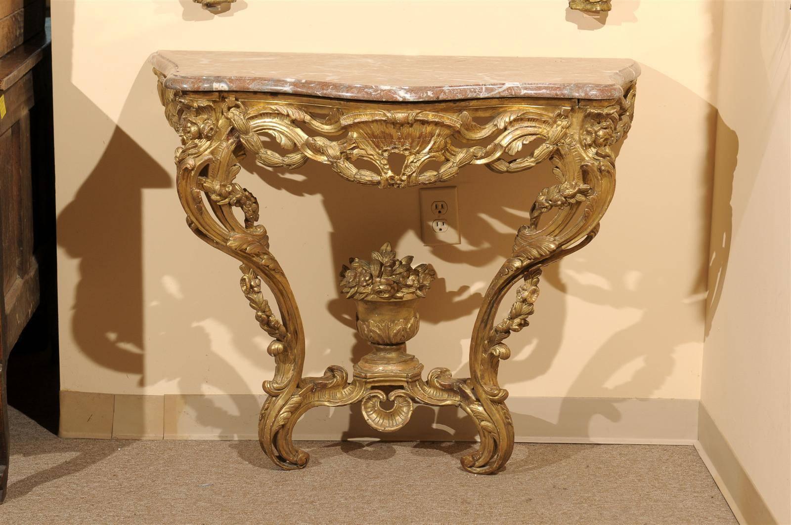 A French Louis XV giltwood wall-mounted console table with "Rouge Royale" marble top, serpentine front, pierced apron and carved urn detail on stretcher. 

William Word fine antiques: Atlanta's source for antique interiors since 1956.