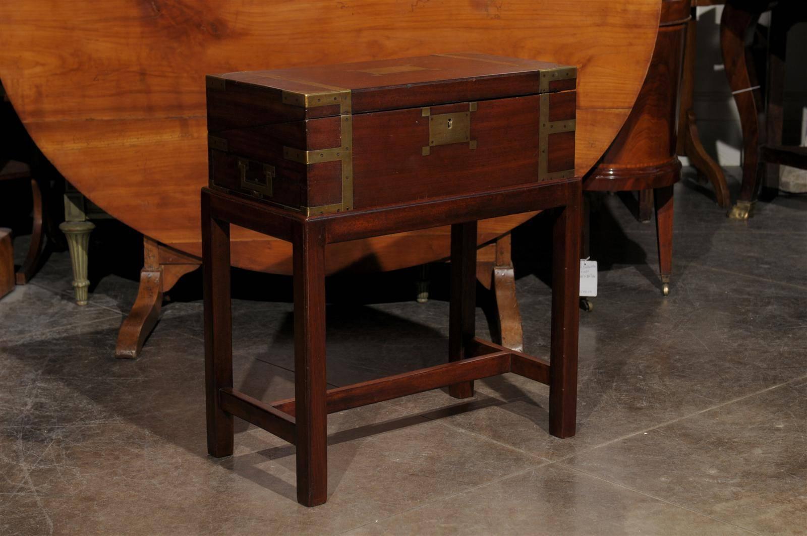 An English lap desk box on custom-made stand from the mid-19th century. This English box on stand is in fact a lap desk, featuring a rectangular box accented with brass accents. The box has been mounted on a mahogany base with straight legs and