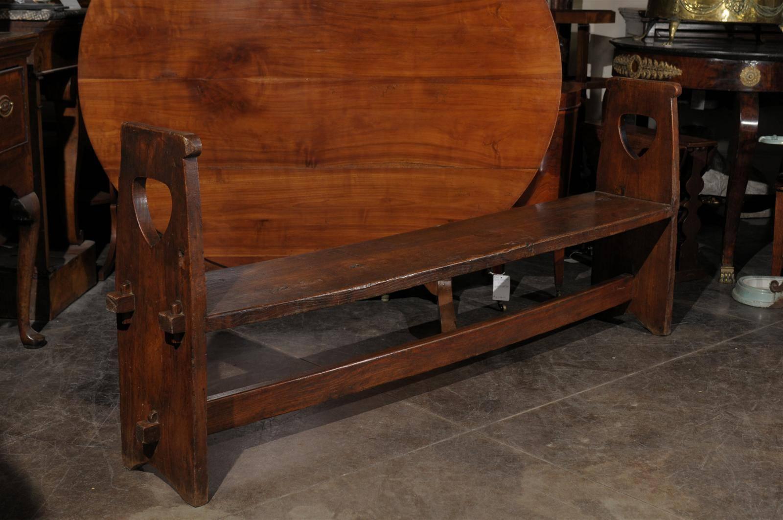 A long Italian wooden bench with stretcher and sides from the 19th century. This narrow wooden Tuscan bench from the early 19th century features a stretcher and a rectangular seat. This seat is inserted in groves in the sides, and has knuckles that