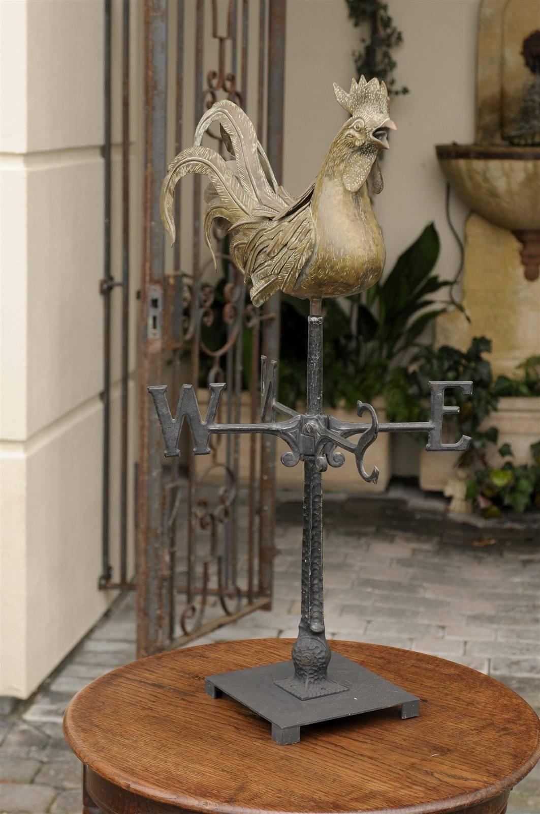 An Italian brass rooster weathervane on base from the mid 20th century. This elegant Italian weathervane features a brass crowing rooster with a beautiful plume of feathers of different lengths and shapes. Roosters have been a popular adornment of