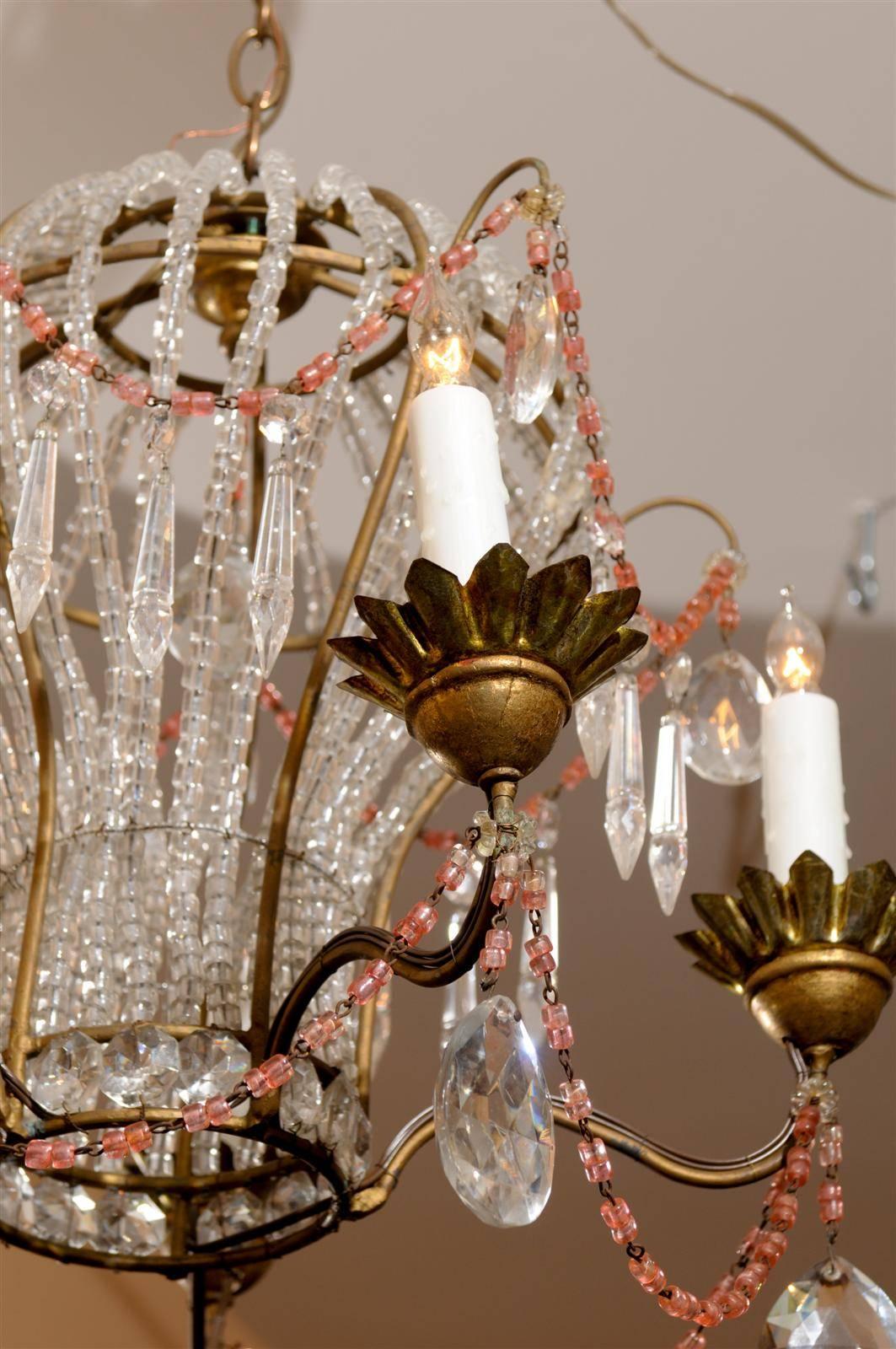 This French five-light glass and crystal chandelier from the mid 20th century features a whimsical balloon shape. The gilded structure supports vertical glass beads, placed in such a manner that we can immediately identify it as a Montgolfière! This
