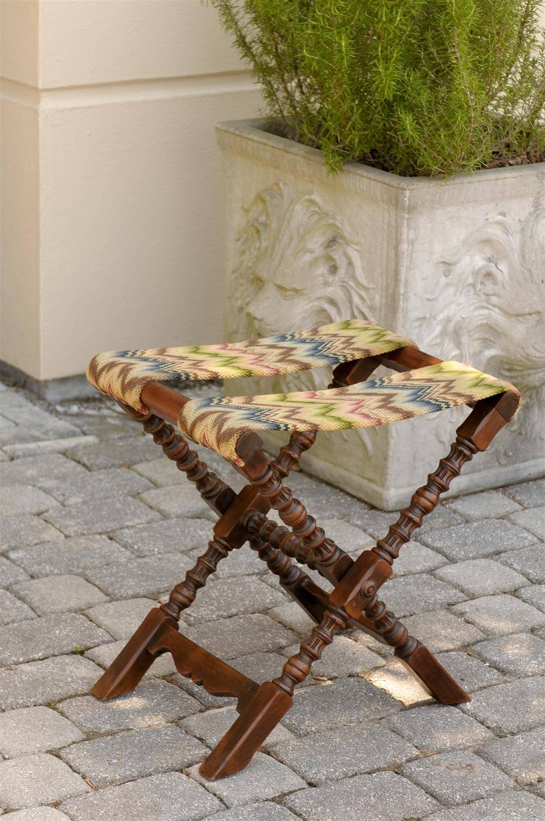 English folding luggage rack with old needlepoint straps.