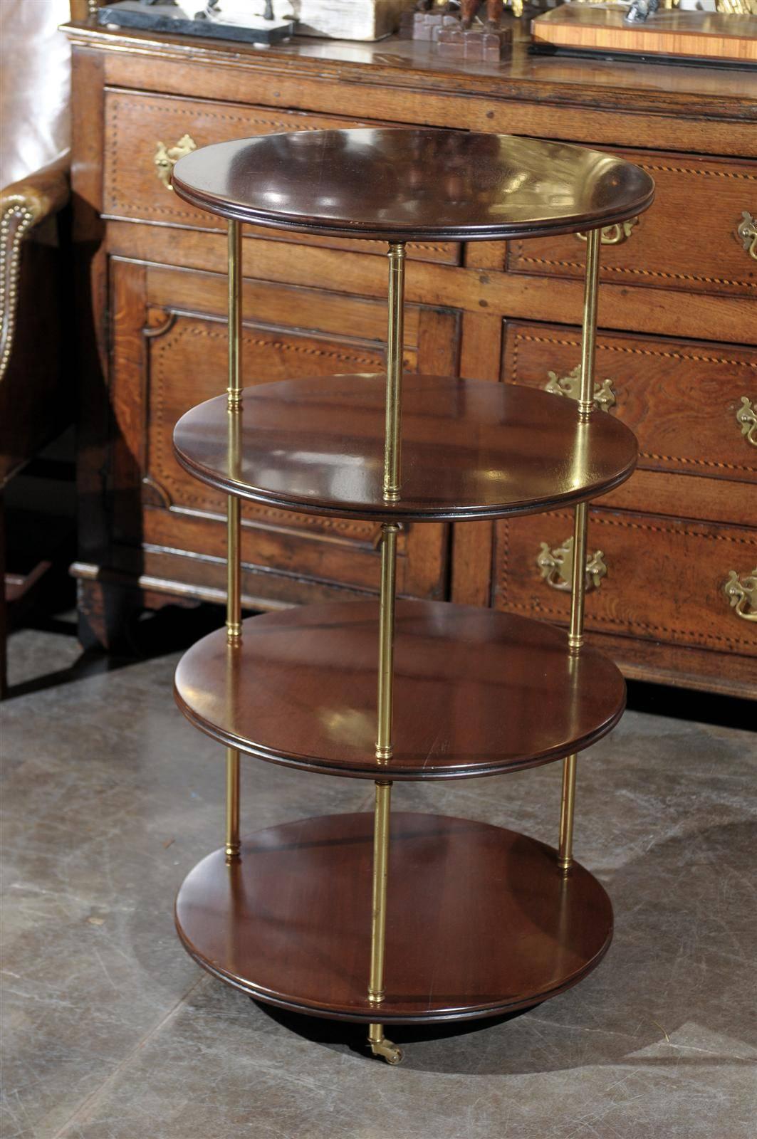 A four tier, round English mahogany and brass trolley from mid century.  This elegant English four-tier trolley features four round mahogany shelves gathered by three brass shafts resting on casters.  This trolley is a perfect example of furniture