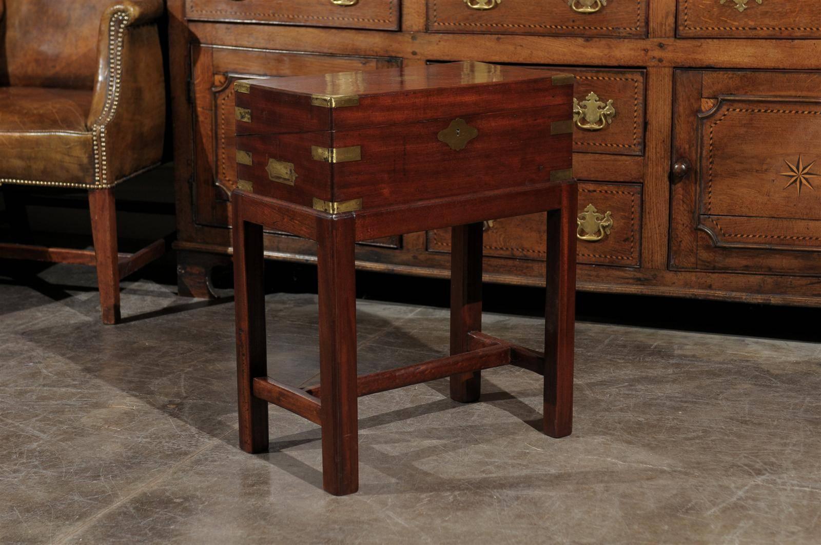 A mahogany English writing box on a four legged stand. This wonderful box on custom stand opens to reveal a slanted small size lap desk fitted with a leather surface for writing. Below the leather writing surface is an enclosed storage area of
