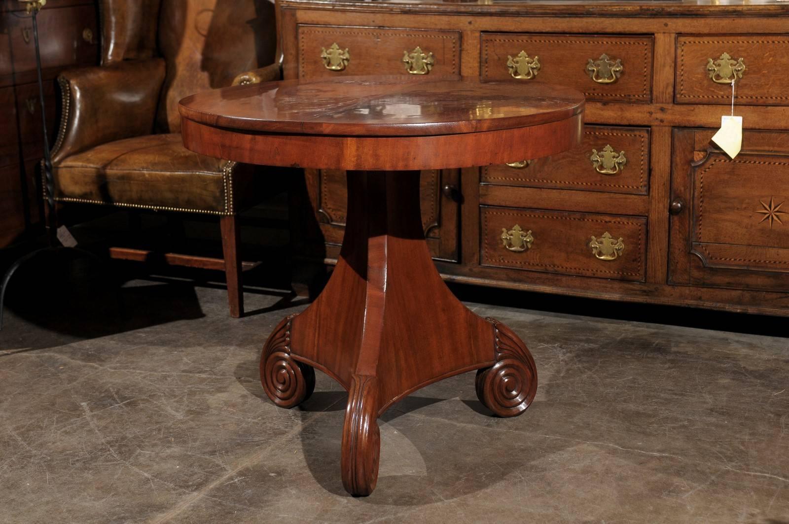 This Austrian late 19th century Biedermeier table features a top made of two half moons, a simple apron, all over an exquisite pedestal base. The eye is immediately drawn to this elegant tripod base, made of volutes with stylized acanthus leaves.