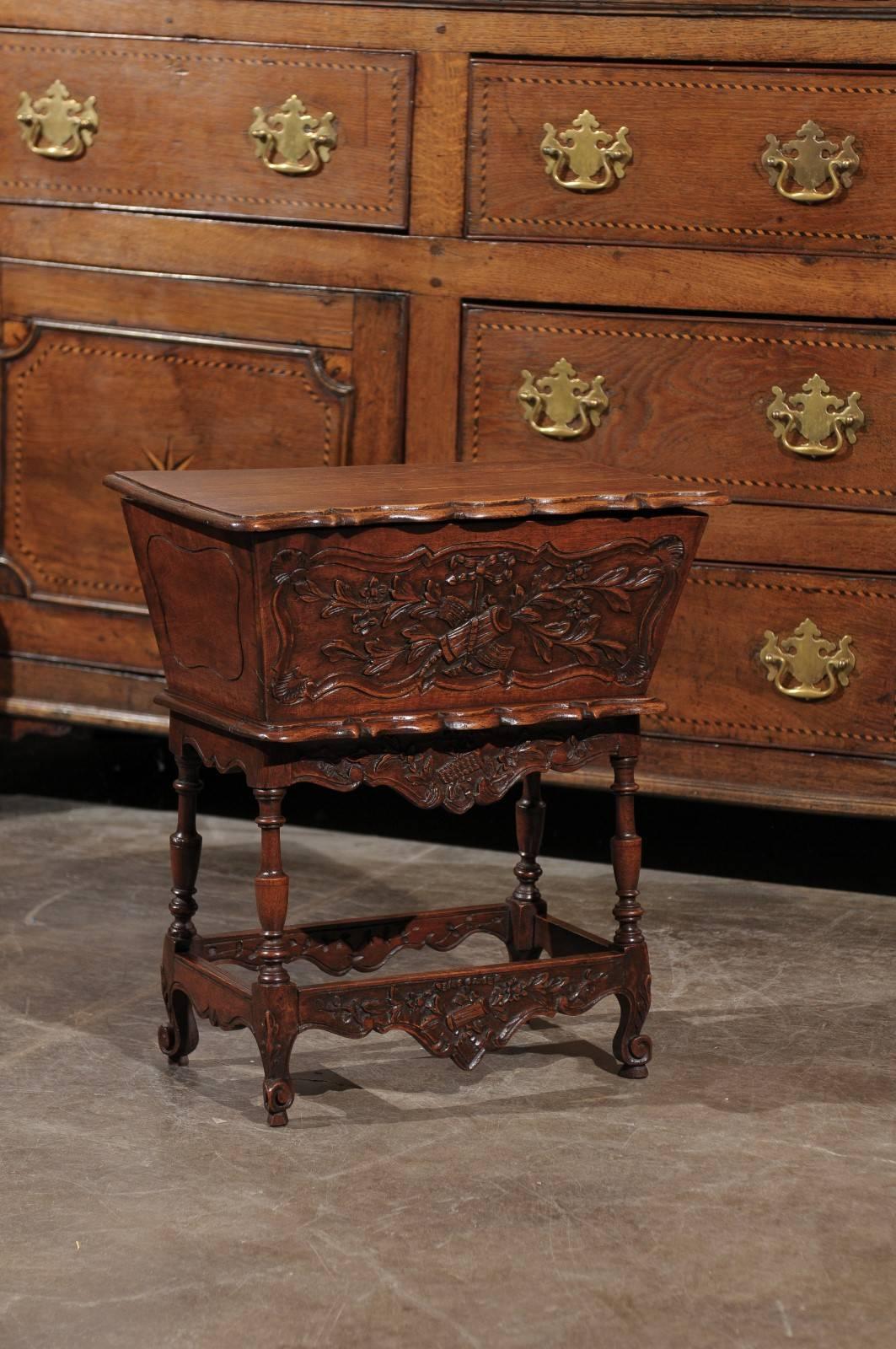 A French Louis XV style pétrin (dough bin) table from the early 20th century. This French petite wooden carved dough bin table from the 1900s-1920s features a rectangular hinged top with scalloped front opening to reveal the inner section where