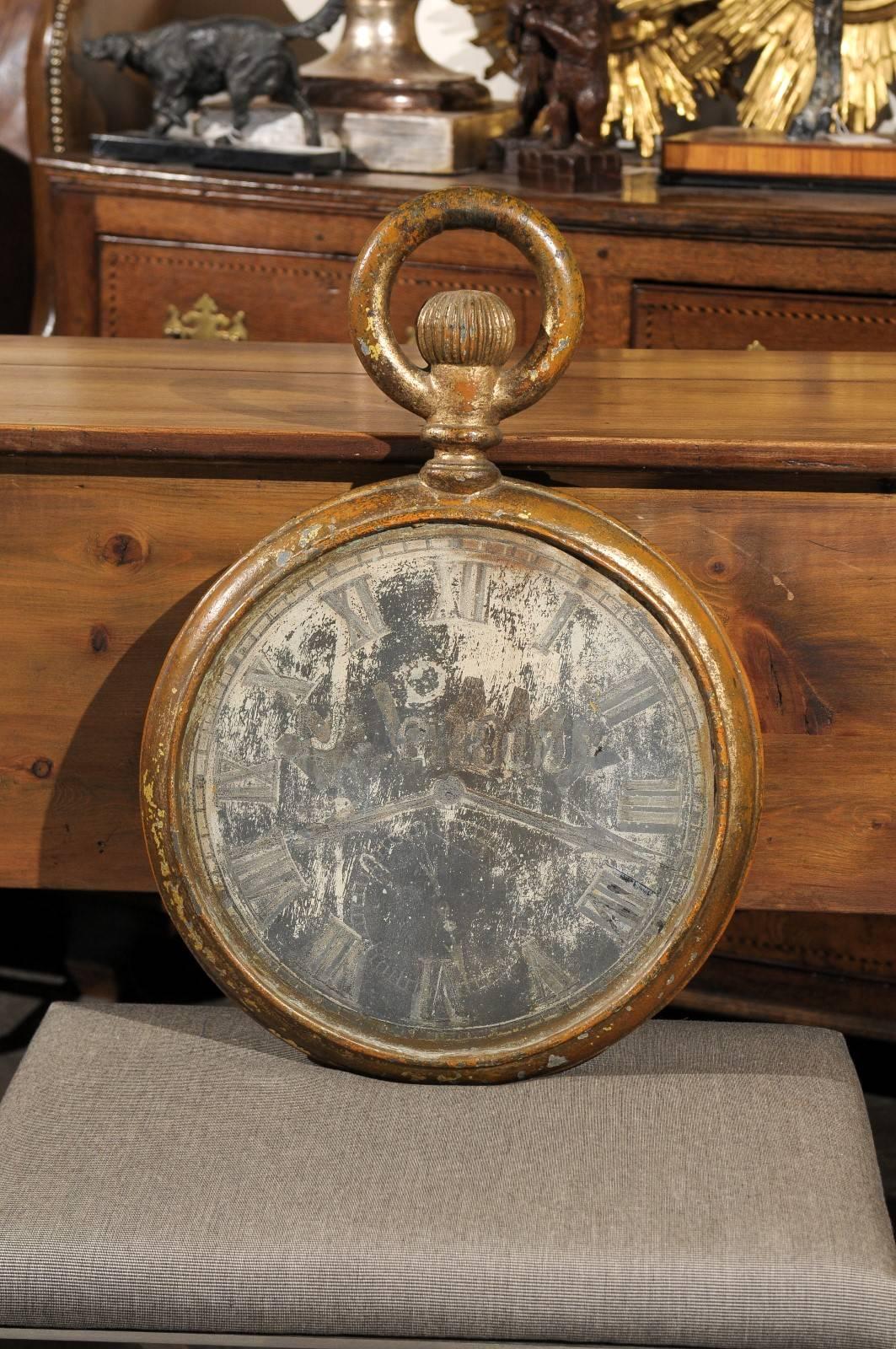 An exquisite French late 19th century tole trade sign depicting an oversized pocket watch. This French clock face trade sign is made of tole with a gilded iron circular bow at the top. This turn of the century trade sign is painted on both sides