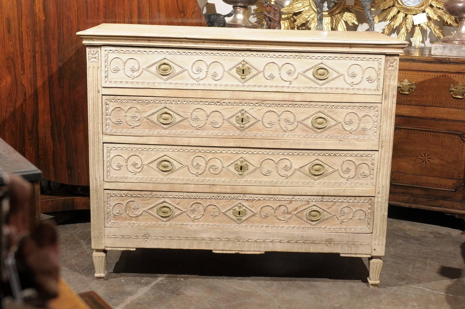 French commode with floral and geometrical motifs from the 19th century.  This late 19th century French bleached commode features a three-plank rectangular molded top over four capacious dovetailed drawers and framed molded sides. Each drawer is