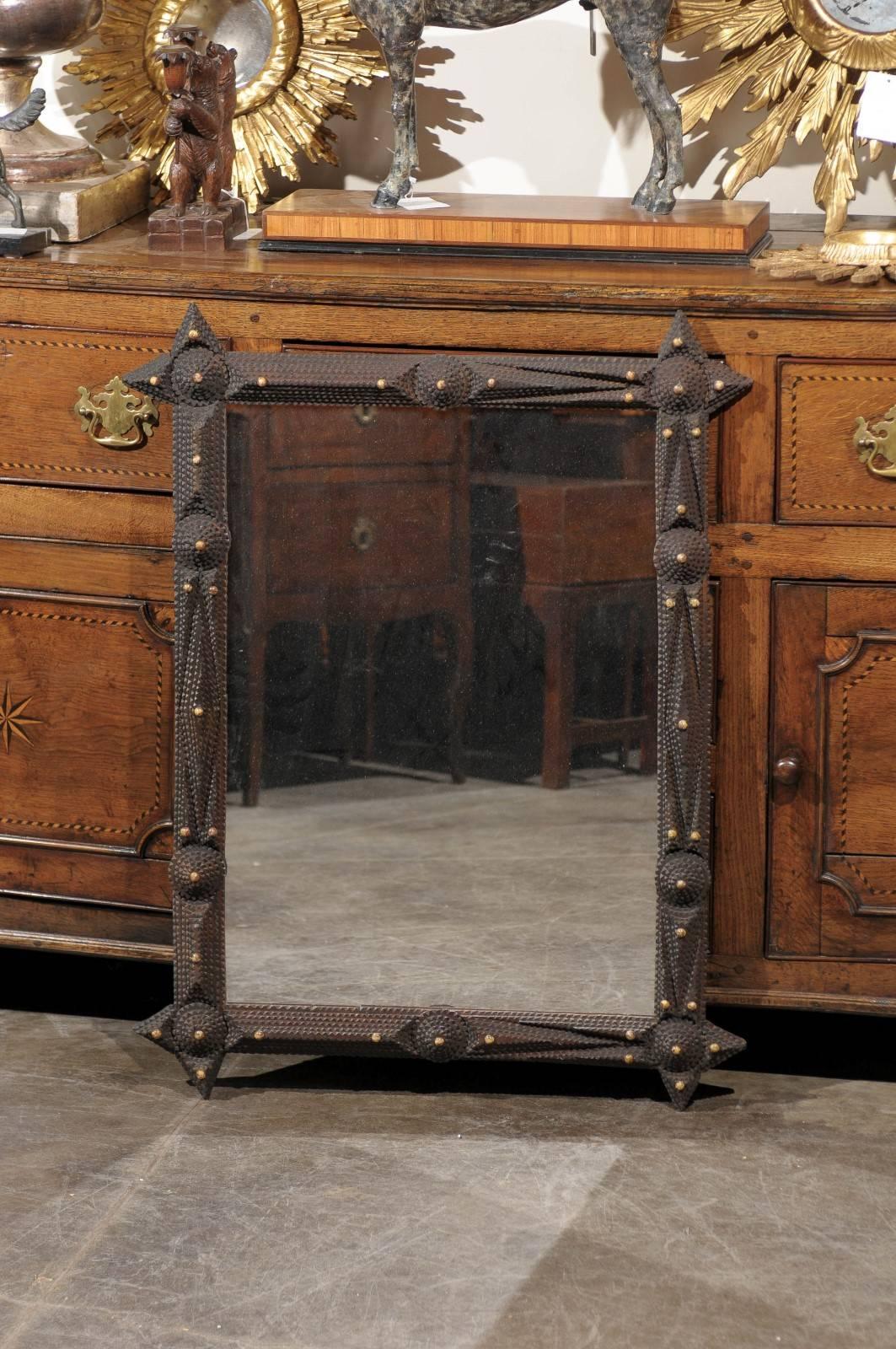 A French Tramp Art carved mirror from the turn of the century with bone inlay. This French Tramp Art mirror from circa 1900 has a vertical rectangular shape with the unmistakable Tramp Art texturized signature: the technique of notching and layering