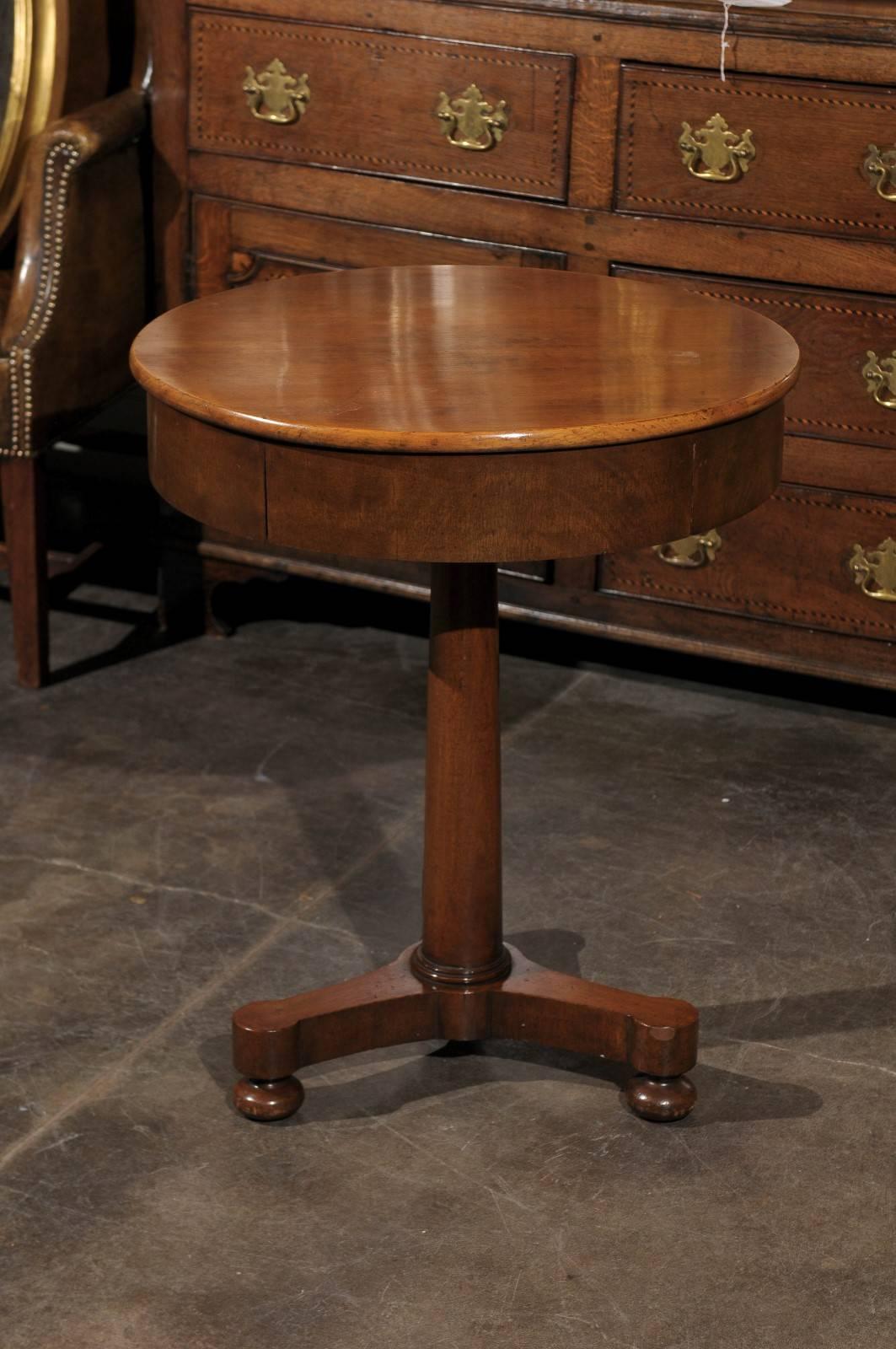 Round pedestal table with one drawer.