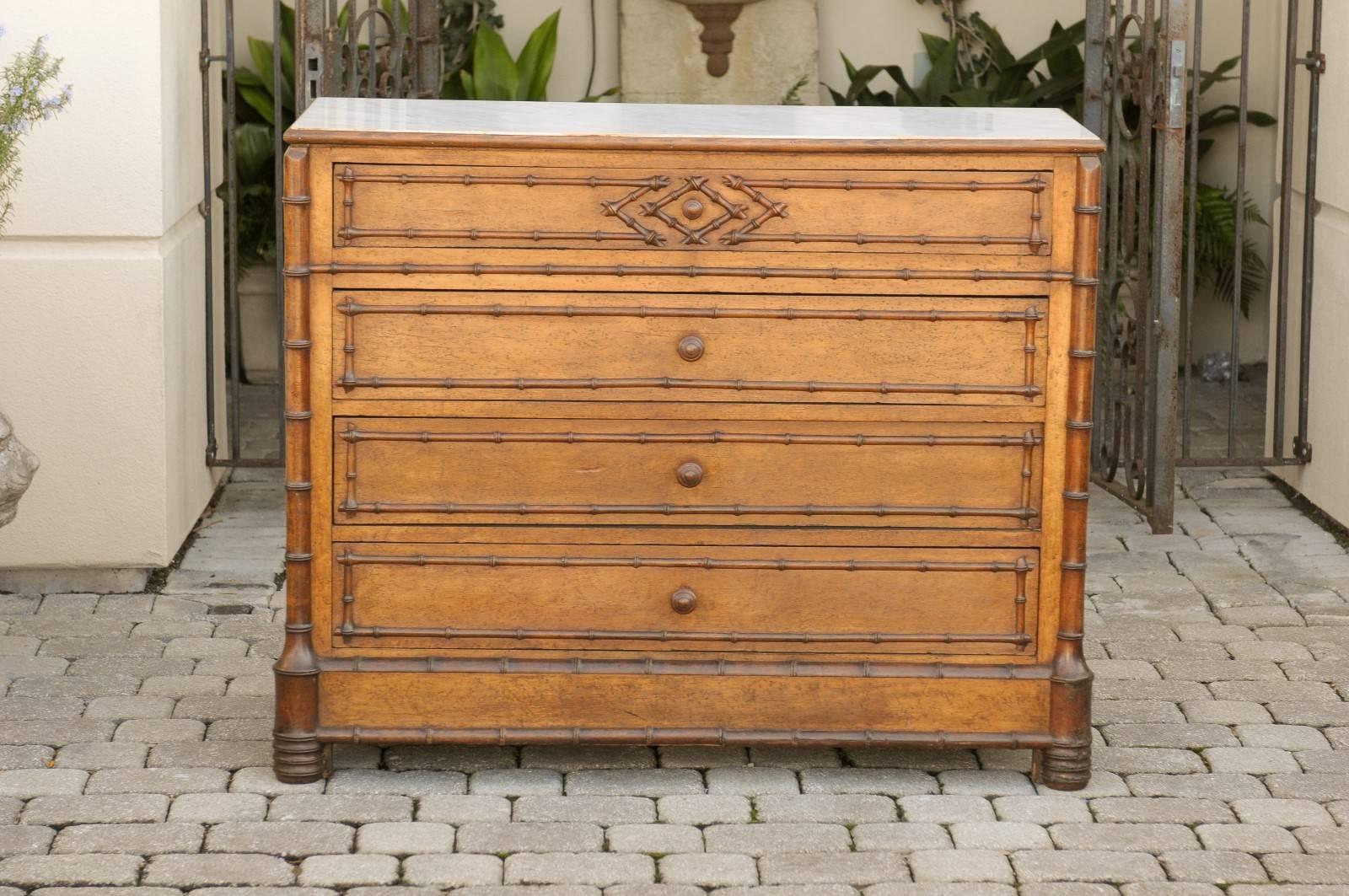 English marble top chest of drawers with faux bamboo trim.  This 19th century English chest of drawers, surrounded by faux bamboo trim and posts ending on bobbin-turned feet at the front, offers a great deal of storage capacity. A rectangular white