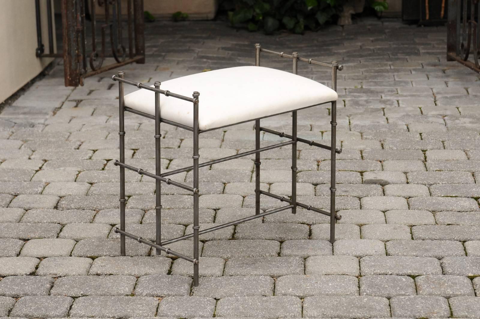 A French metal upholstered bench from the mid-20th century. This light and elegant bench, circa 1970 features a soft white muslin seat resting on a simple geometric frame. The base is made of a thin metal armature, adorned with simple metal rings,