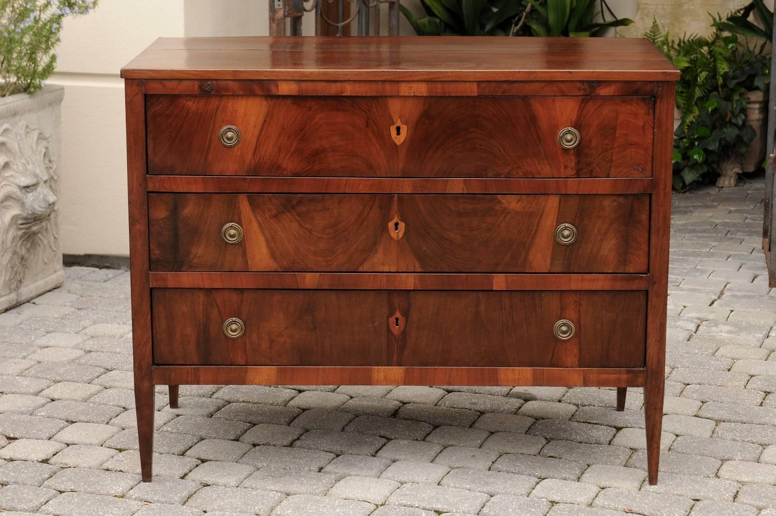 This Italian commode from the early 19th century features a rectangular top over three drawers. The exquisite pattern of the oyster veneer contrasts nicely with the simplicity of the lines. This Italian three-drawer chest from circa 1820 has indeed