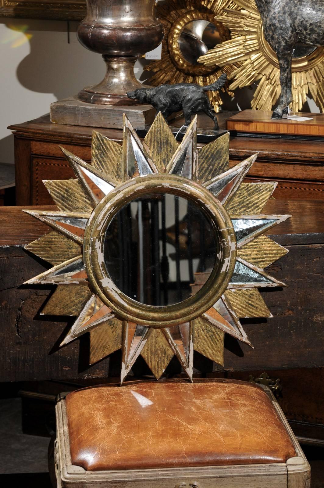 This French sunburst mirror from the mid-20th century features a clear circular mirror in the centre, 10.5 