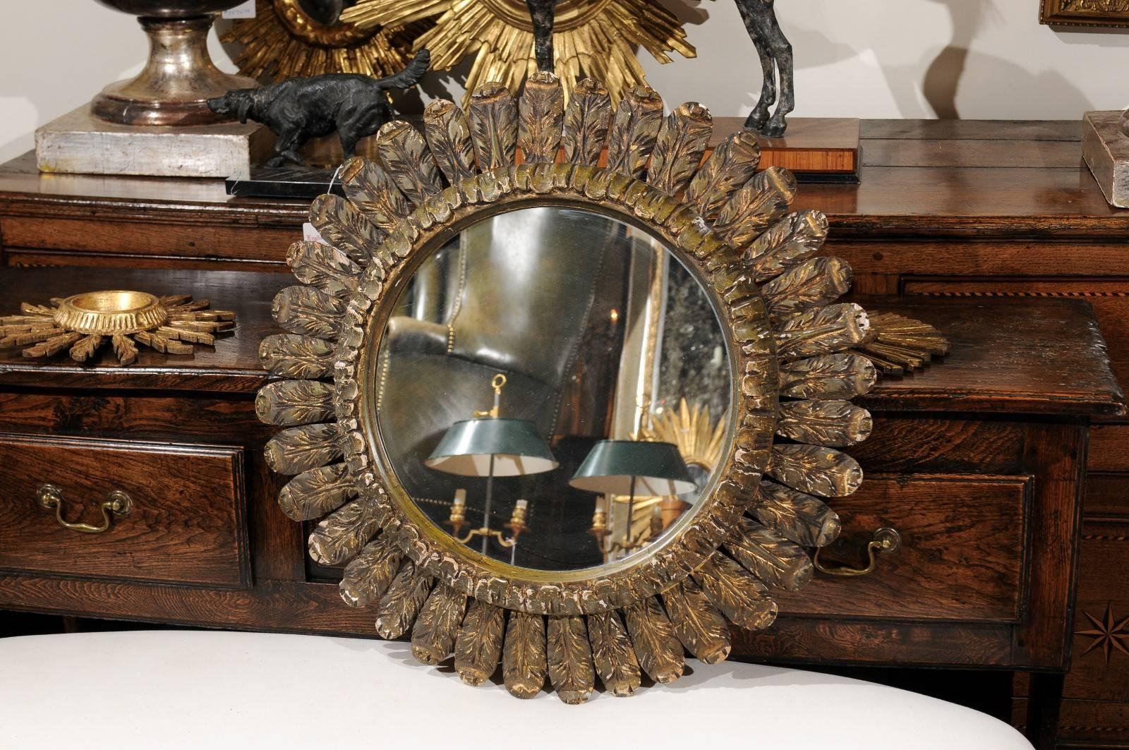 This Italian vintage medium size mirror features a clear central glass surrounded by a carved and raised molding, as well as a ring of harmonious delicately carved leaves. This Italian mirror is in very good condition with nice aging in the finish,