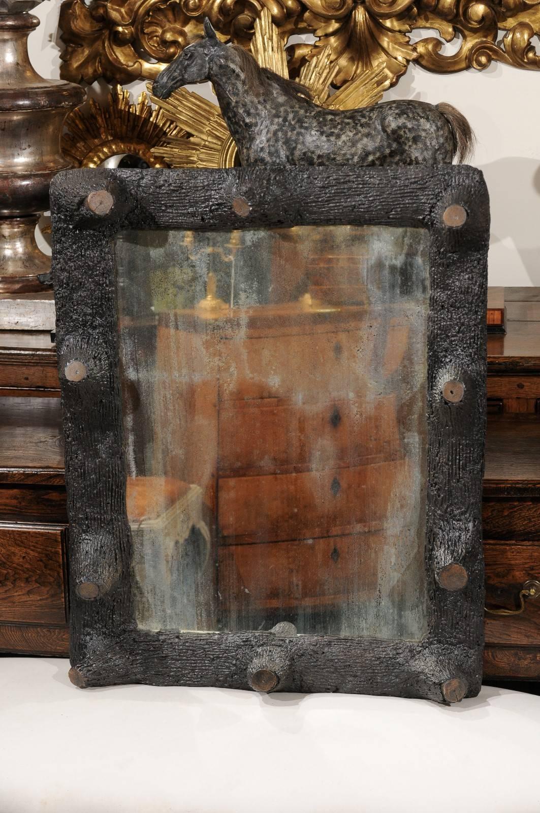 A French faux-bois mirror from the late 19th-early 20th century. This distressed glass mirror circa 1900 features a faux wood frame with truncated branches all around. Faux-bois, from the French term for false wood, refers to the artistic imitation