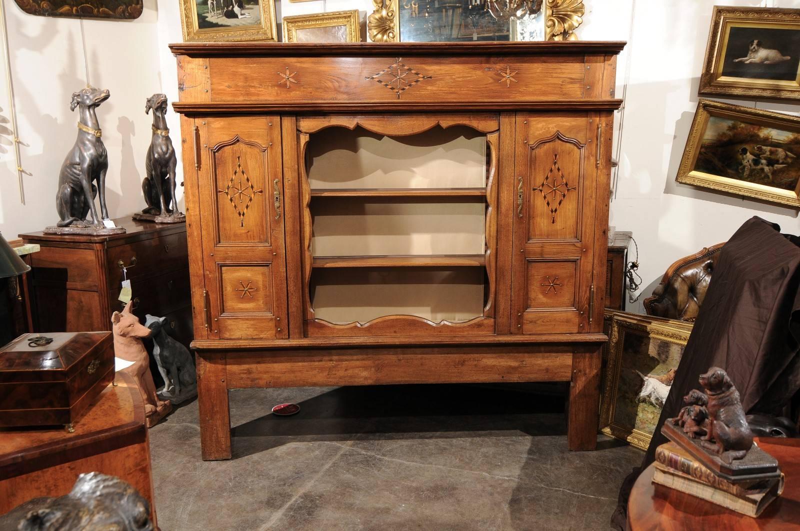 This French 19th century fruitwood vaisselier features a central opened shelving niche beautifully cut-out with a scalloped outline on the surround, flanked with two lateral doors. Each door opens to reveal additional storage and is made of two