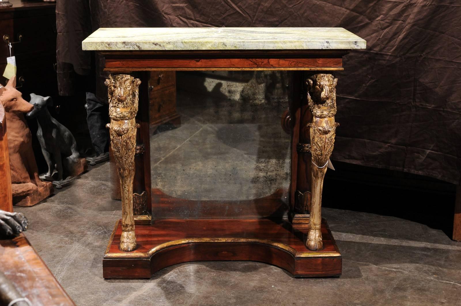 An English William IV pier table with green jasper top from the mid-19th century. This English console table from circa 1840 features a magnificent green jasper top over two skillfully carved and gilded wooden ram's head monopodia raised on hoofed