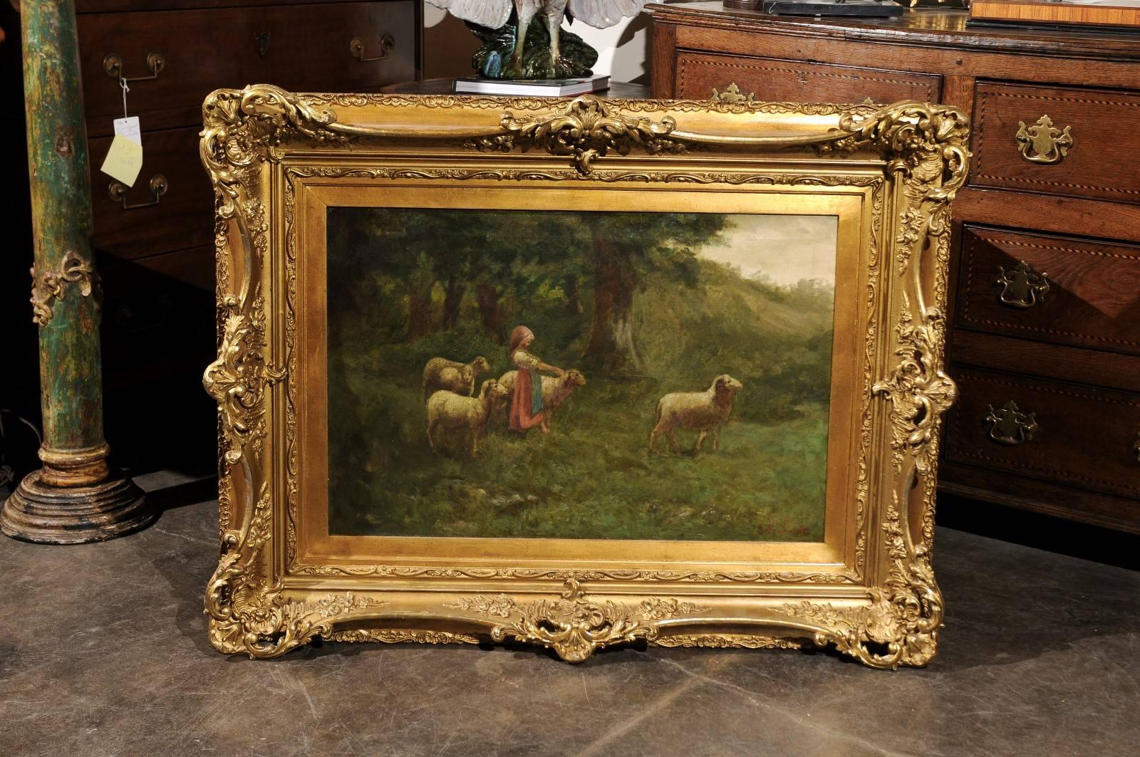 This continental large size turn of the century (19th-20th) oil painting on canvas is set in an antique giltwood frame. The scene is placed in what seems to be the edge of a forest. A lovely shepherdess, dressed in red and blue, is surrounded by