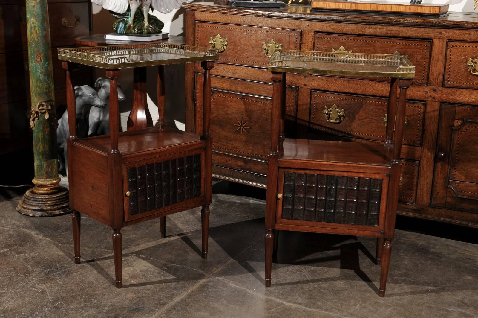 This pair of English turn of the century (19th-20th) nightstand side tables is made of old antiqued mirrored tops surrounded by a three-quarter brass gallery. These tops are supported by delicate Doric columns with a discreet entasis bulge, creating