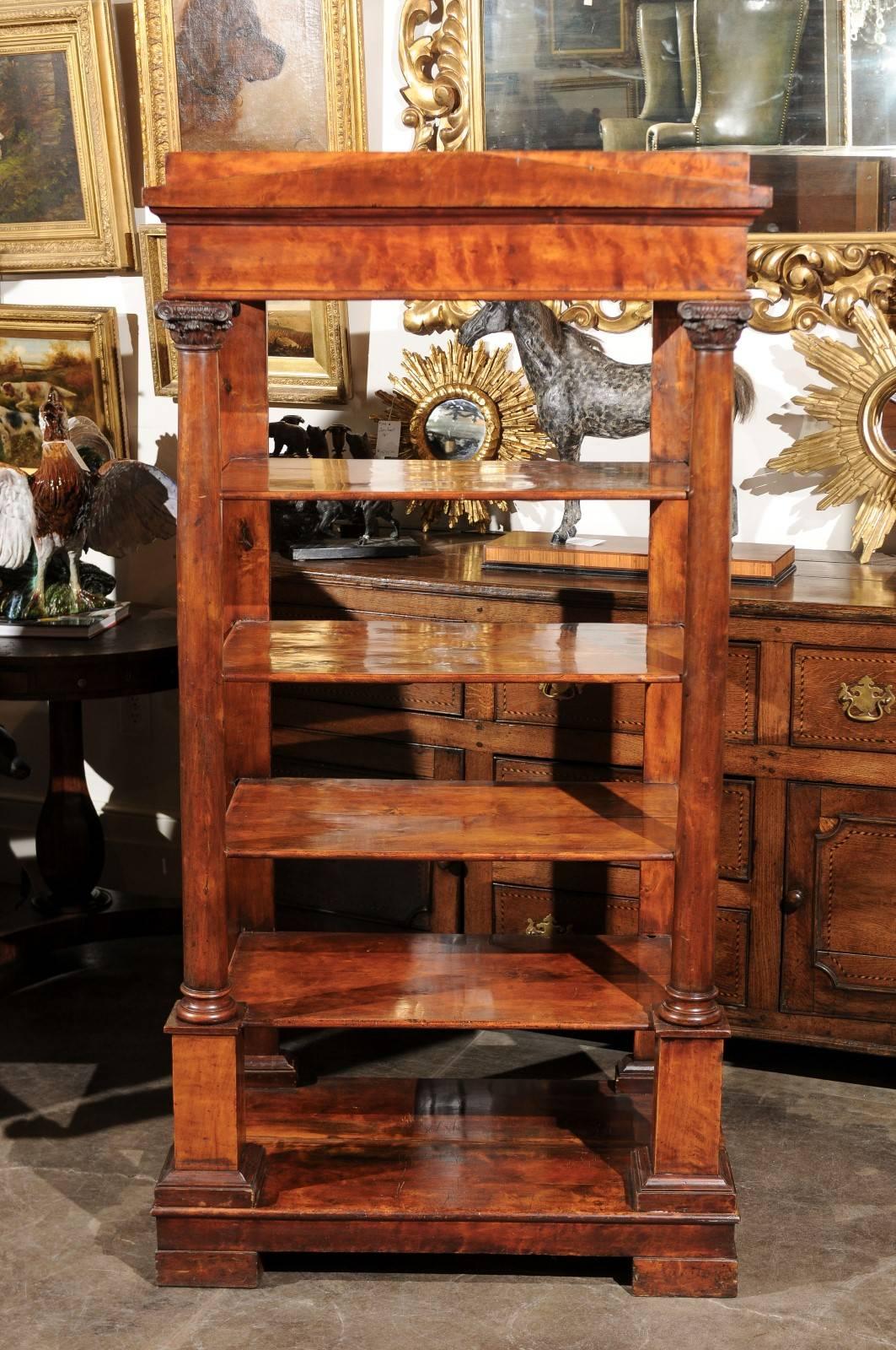 This exquisite early 19th century Austrian Biedermeier open bookcase features a deep honey colored fruitwood frame made of a rectangular top with triangular pediment, reminiscent of Greek temples, over five open shelves. The classical decorative