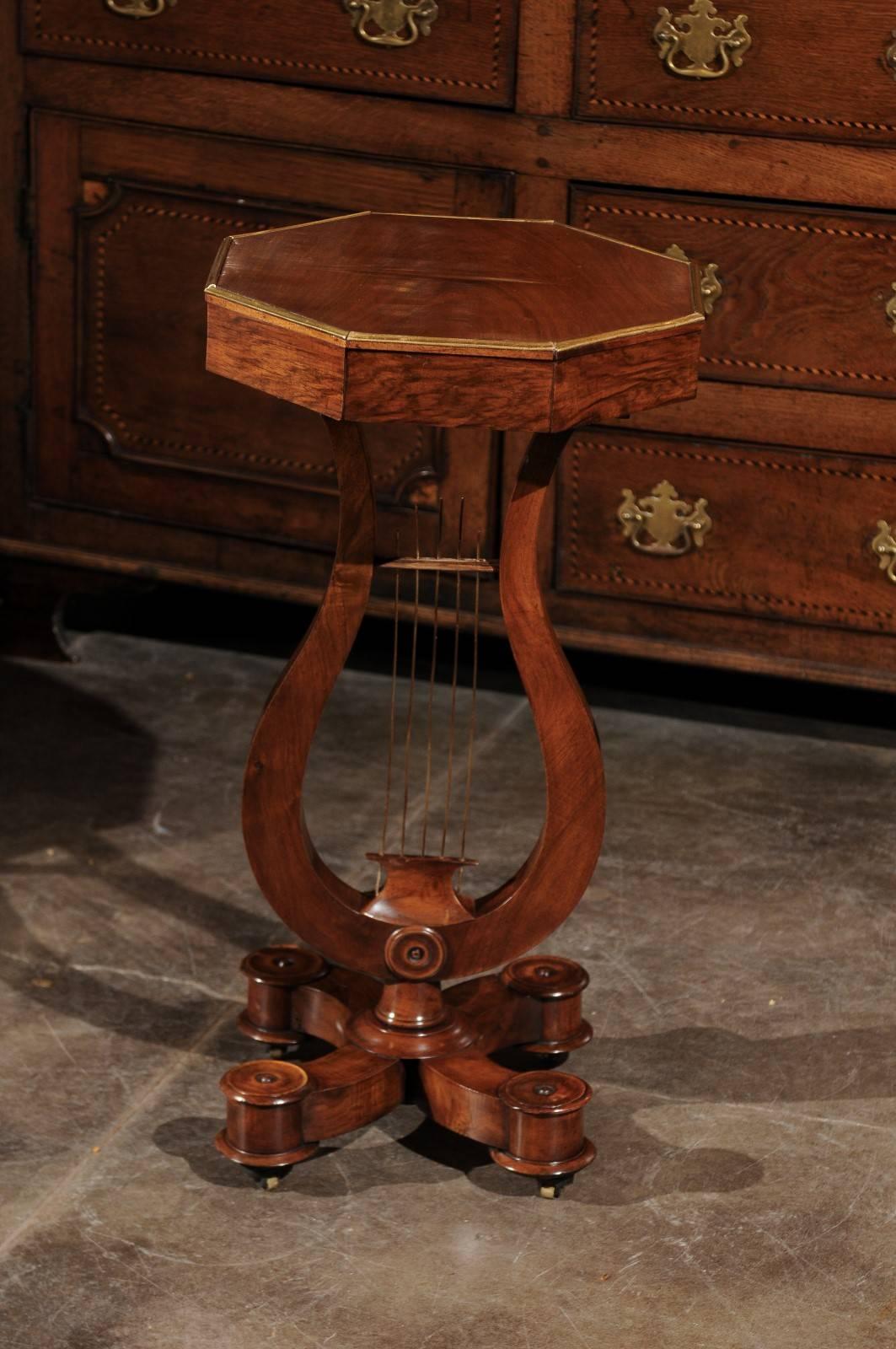 This English period Regency mahogany pedestal drinks table from the early 19th century features an octagonal top decorated with a brass frame on the surround, over an exquisite lyre shaped pedestal base. What a charming detail, the addition to the