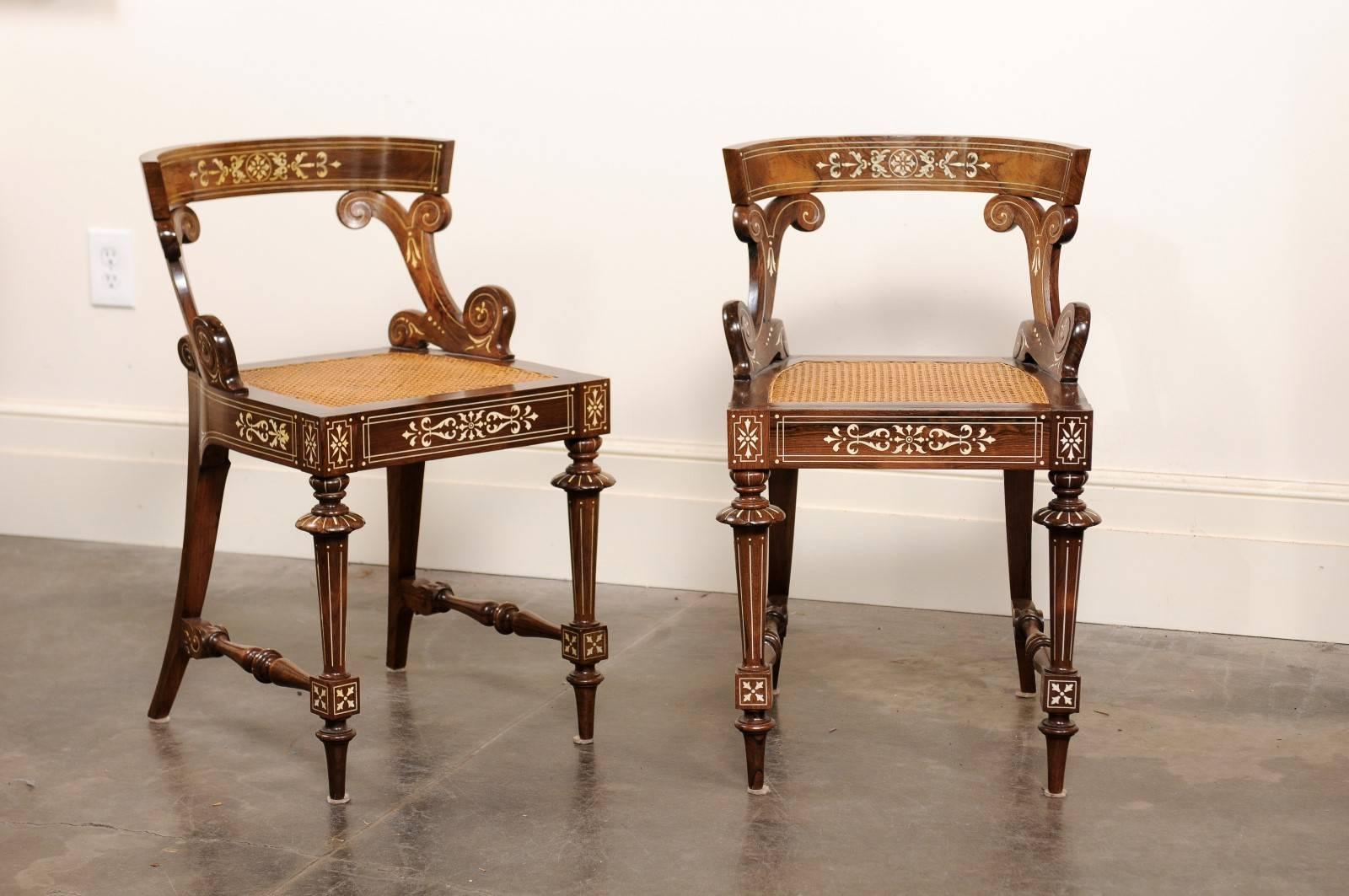 This pair of small size Anglo-Indian slipper chairs from the early 20th century features an exquisite décor combined with elegant lines. The open barrel backs are adorned on their top rail by a delicate marquetry made of bone inlay and supported by