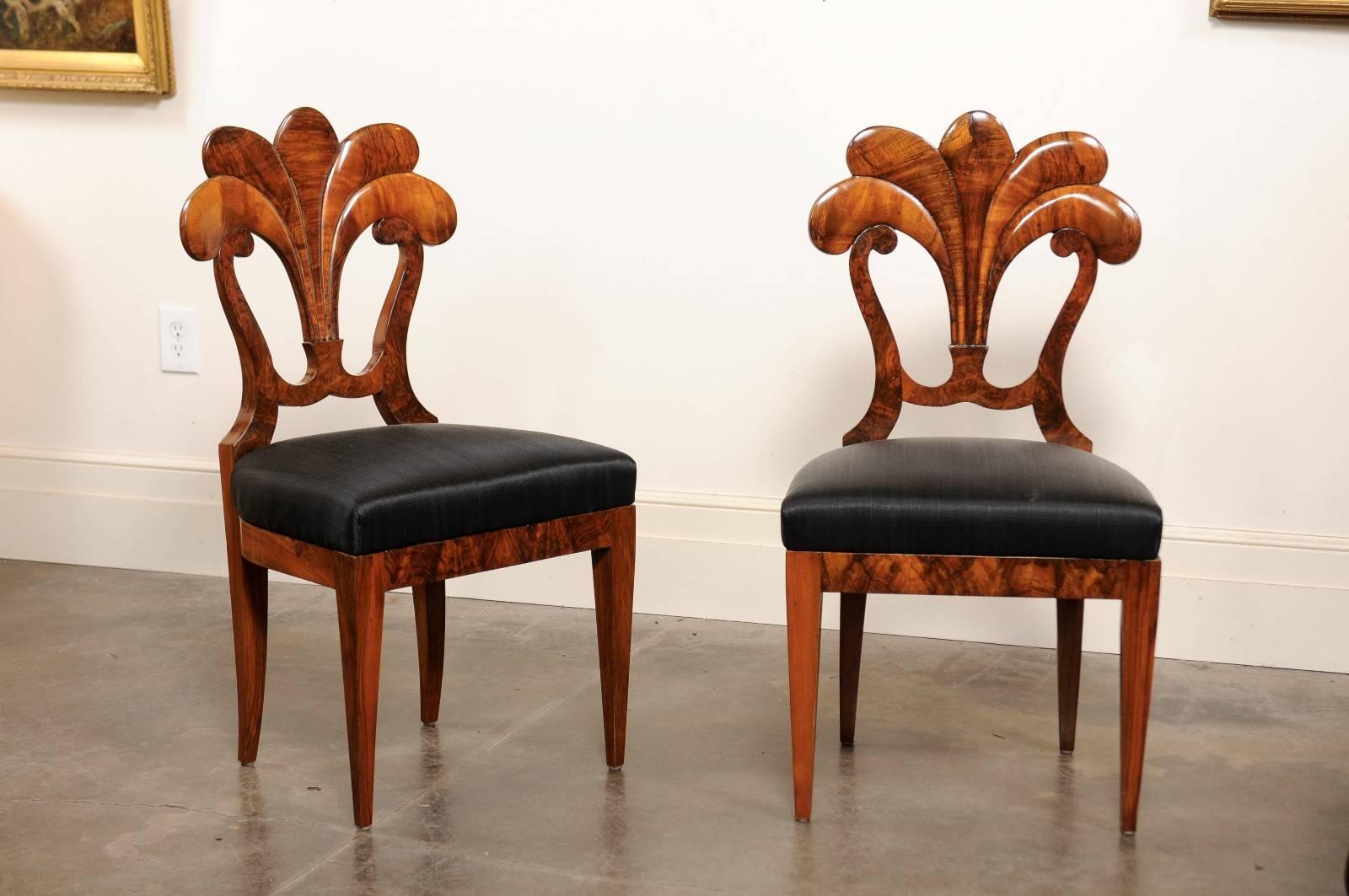 This set of six Austrian Biedermeier chairs from the first quarter of the 19th century features exquisitely carved fan shaped backs supported on each side by delicate volutes. This is one of the most spectacular set of Biedermeier dining chairs we