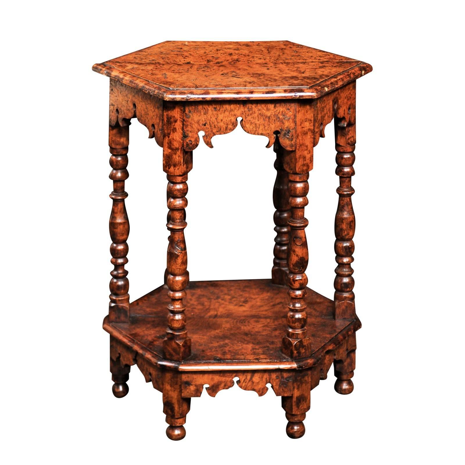 This English mid-19th century burl wood side table features an hexagonal tow-plank top with bevelled edge over an exquisitely carved apron. Six turned legs support the ensemble and secure a lower shelf. The same chinoiserie style scalloping, raised
