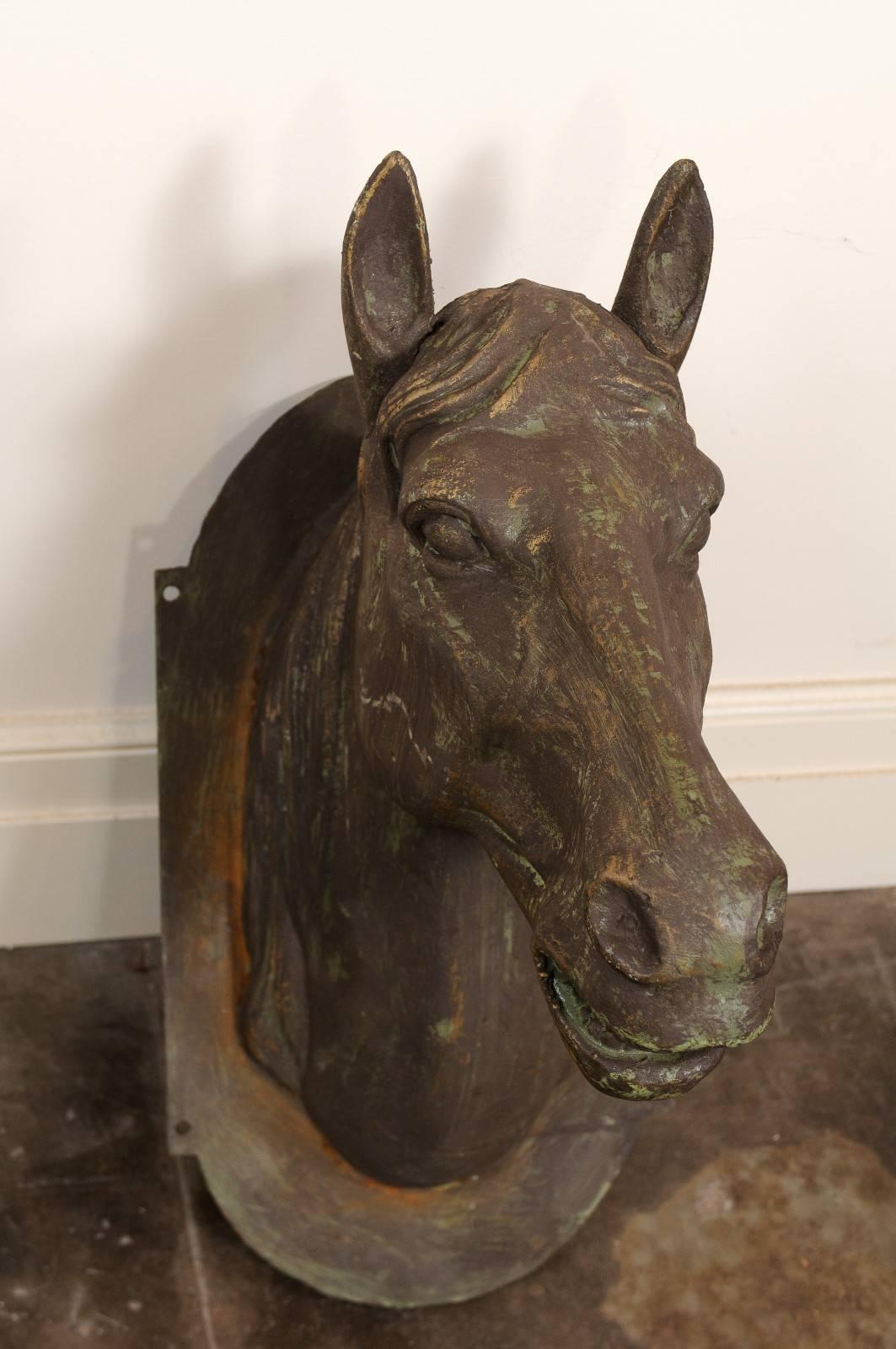 This exquisite horse head sculpture from the mid-20th century features a cast iron head mounted on an oval backplate. Very detailed, the horse features great realism with its opened mouth. Perfect to be mounted on the wall, the backplate has four