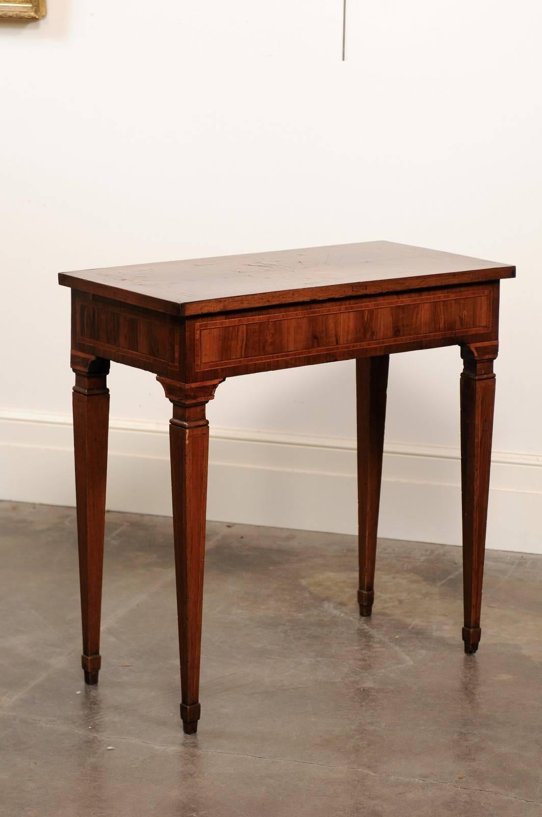 This Italian console table from the late 18th century features an exquisite rectangular top decorated with a delicate marquetry. An inlaid banding frames the top, receiving in its centre a beautifully designed star motif. The apron is also adorned