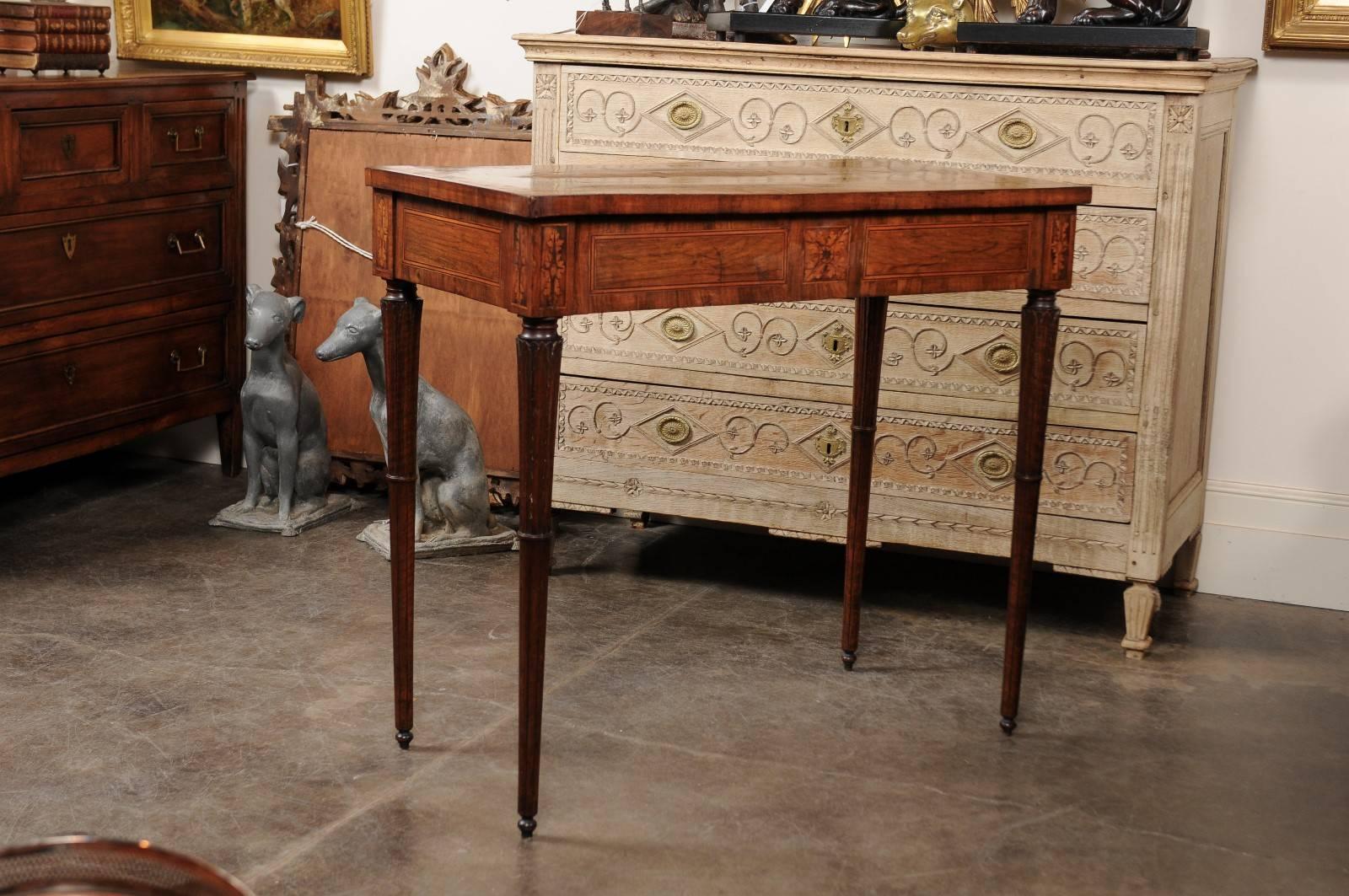 This Italian console table from the 18th century features an exquisite walnut veneered top with delicate inlay. A thin polygonal banding decorates the center of the table, contrasting beautifully with the darker veneer in the surround. The apron is