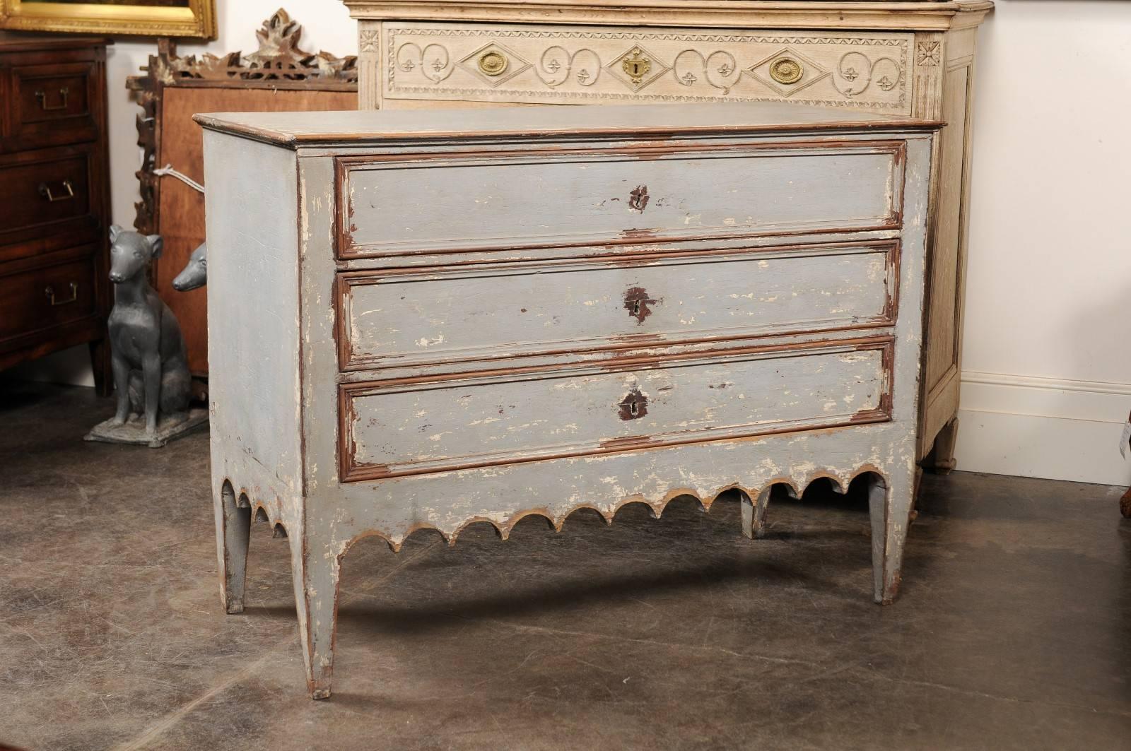 This Portuguese painted wood commode from the early 19th century features a rectangular top with rounded edges over three nicely dovetailed drawers. The eye is immediately drawn to the skirt, beautifully carved on three sides. The chest is raised on