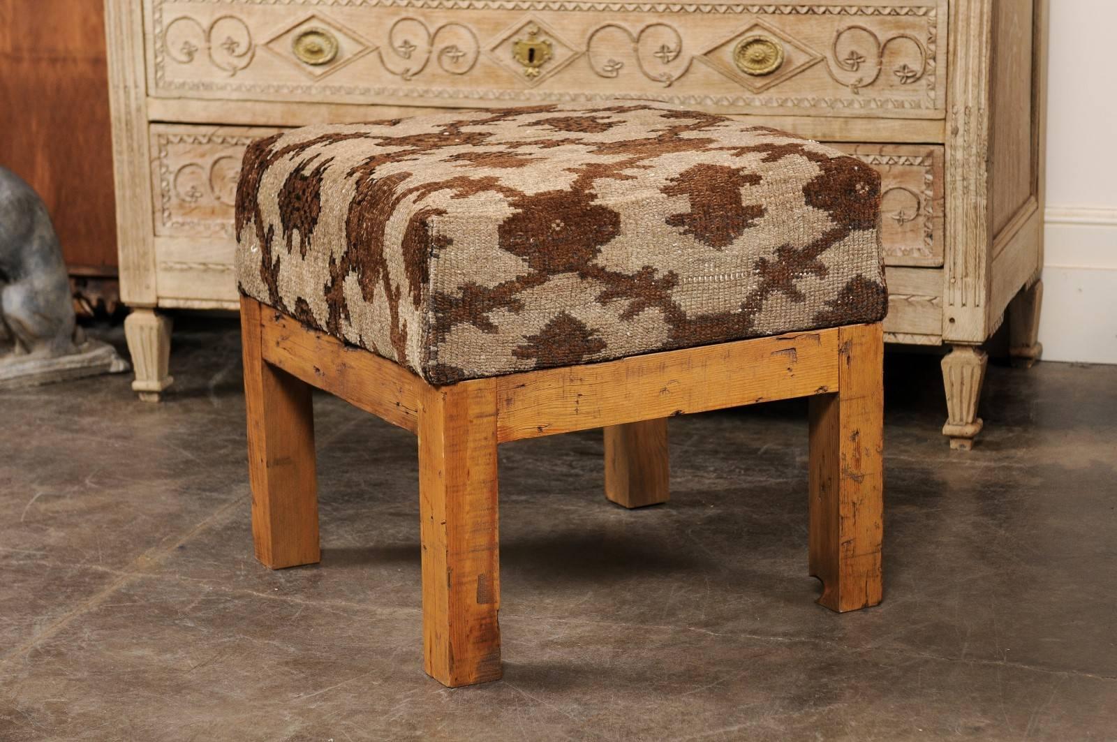 This upholstered square seat stool is newly made of a vintage Turkish wool covered seat over and old wooden base. The comfortable seat features brown colored geometric patterns, perfectly raised on four simple straight legs made of old wood, also