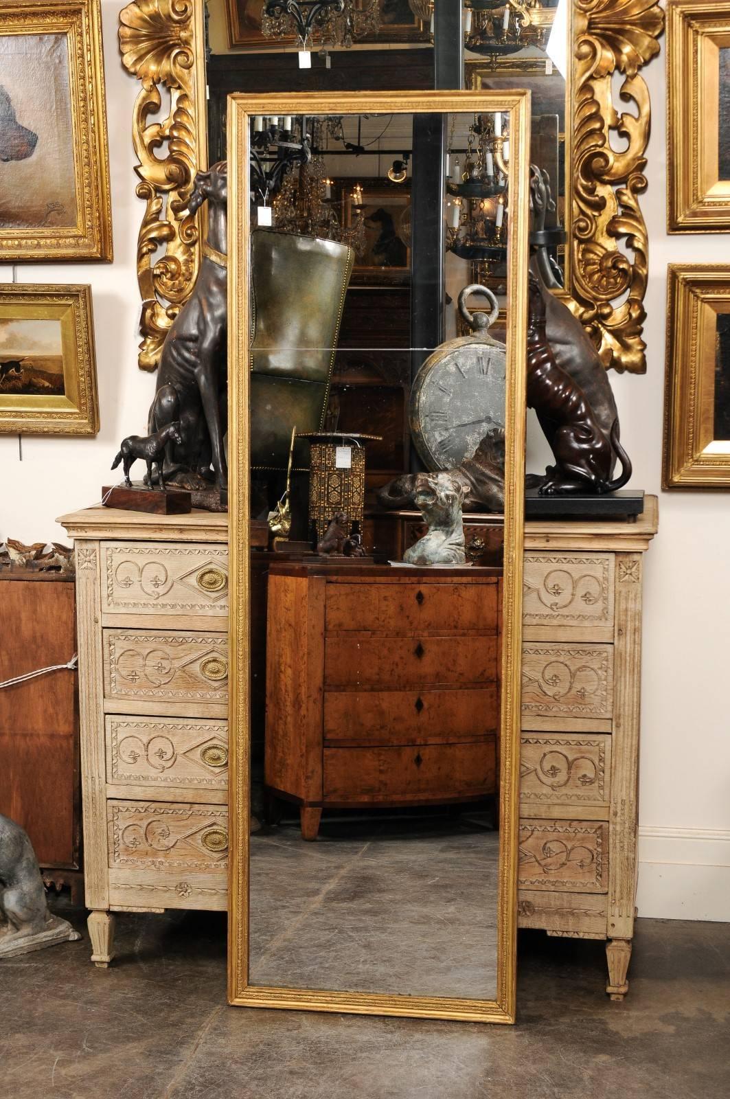 A French full length mirror from the turn of the century (19th to 20th). This full length mirror sits in a giltwood frame adorned with a simple beaded motif. The split glass is original and is actually two pieces, nicely showing its age as even in