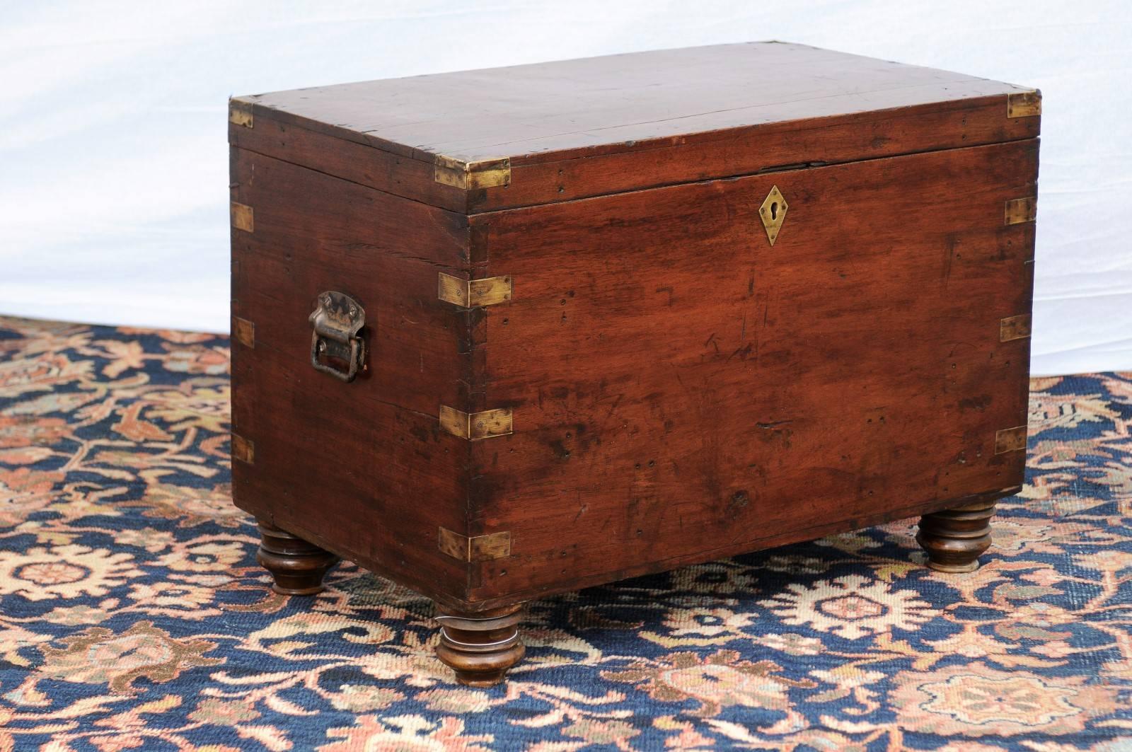 This English Campaign trunk from the late 19th century features a rectangular lift-top discreetly decorated in its corners with brass accents. Two lateral handles are there to help with transport. The trunk, adorned with a simple brass