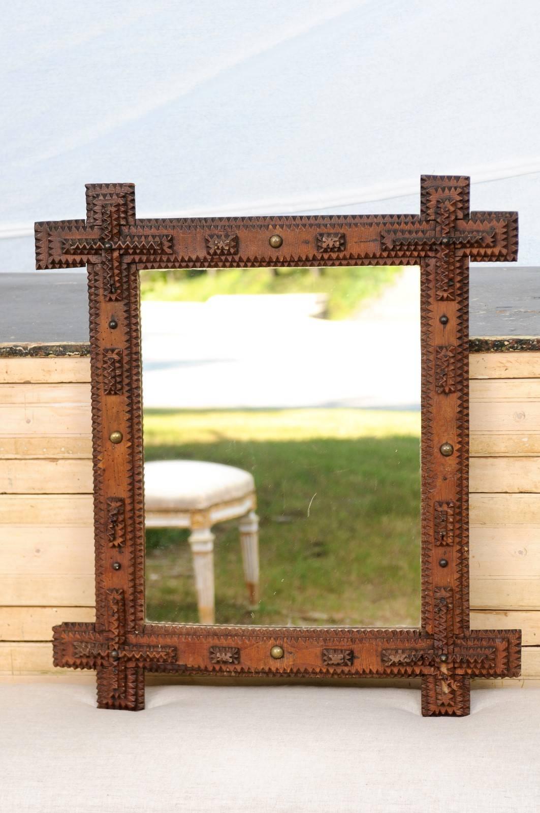 This French small size Tramp Art mirror from the turn of the century (19th to 20th) features a carved linear frame, typical of the Tramp Art style. Made of textured and layered grooves, the four corners are accentuated with additional motifs,