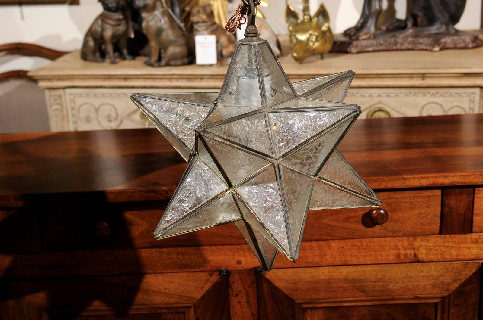 A French vintage star light fixture from the Mid-Century. This small size French chandelier from the mid-20th century features an energizing star shape. The metal frame surrounds the various etched glass panels, protecting the single light secured