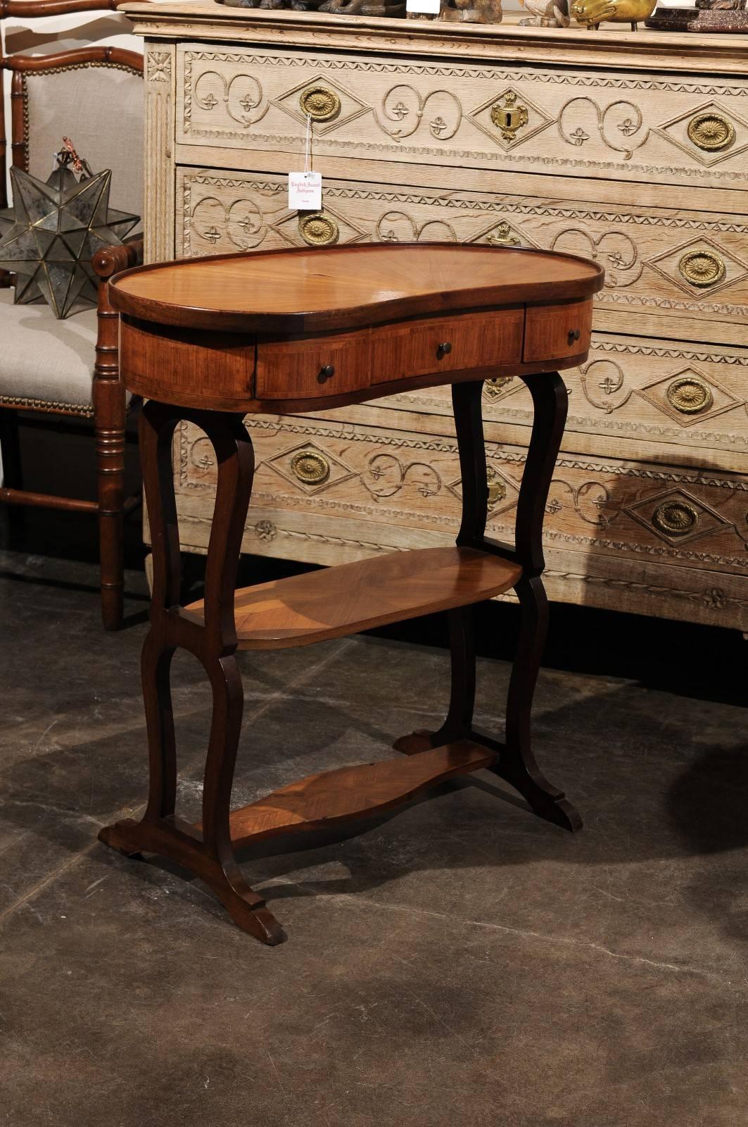 A French bean-shaped top tiered side table with inlay from the 1920s. This French side table features a bean-shape top, delicately decorated with veneer, radiating from a central half-medallion. Without any use of paint, the maker succeeded in