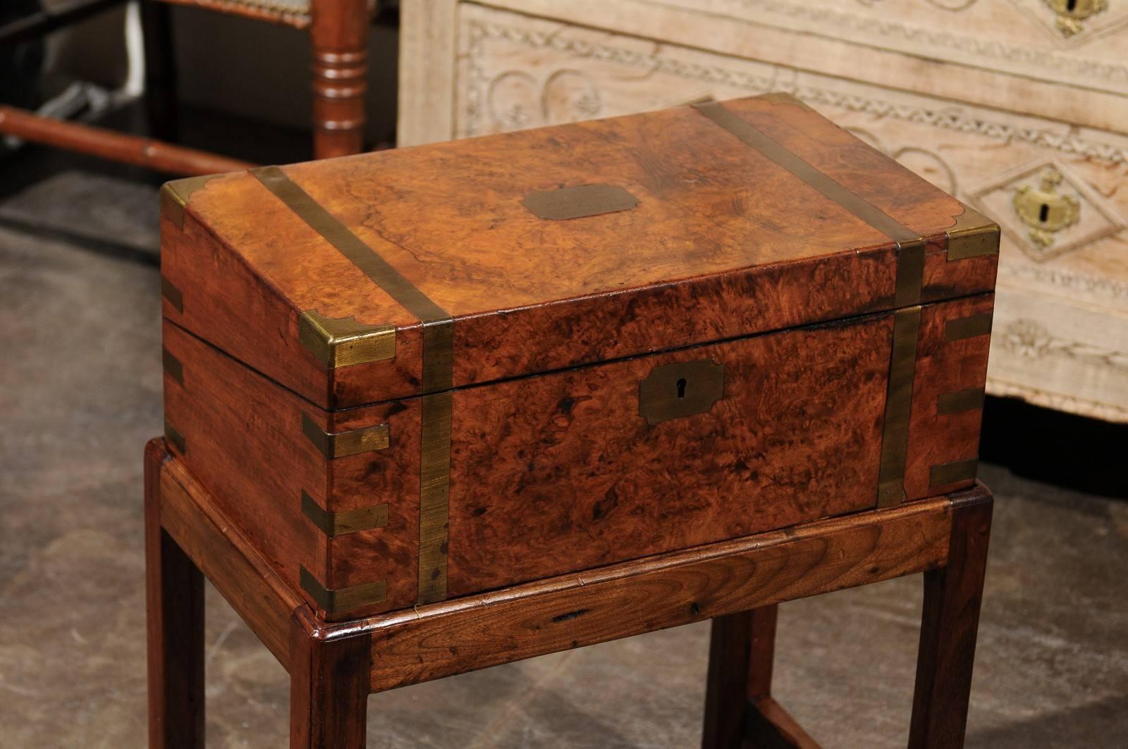 An English burled walnut lap desk from the second half of the 19th century with custom-made stand. This English box on stand features a rectangular top over a custom-made walnut stand with cross stretcher. The brass bound box opens to reveal a black