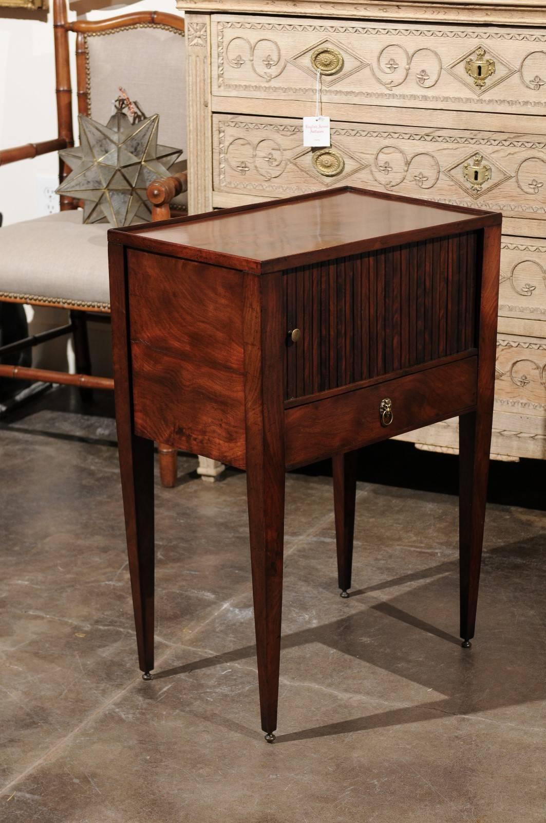 An English wooden side table with tambour door and single drawer from the late 19th century. This English side table features a rectangular tray-top over a sliding tambour door, revealing a small storage area, perfect to place books and small