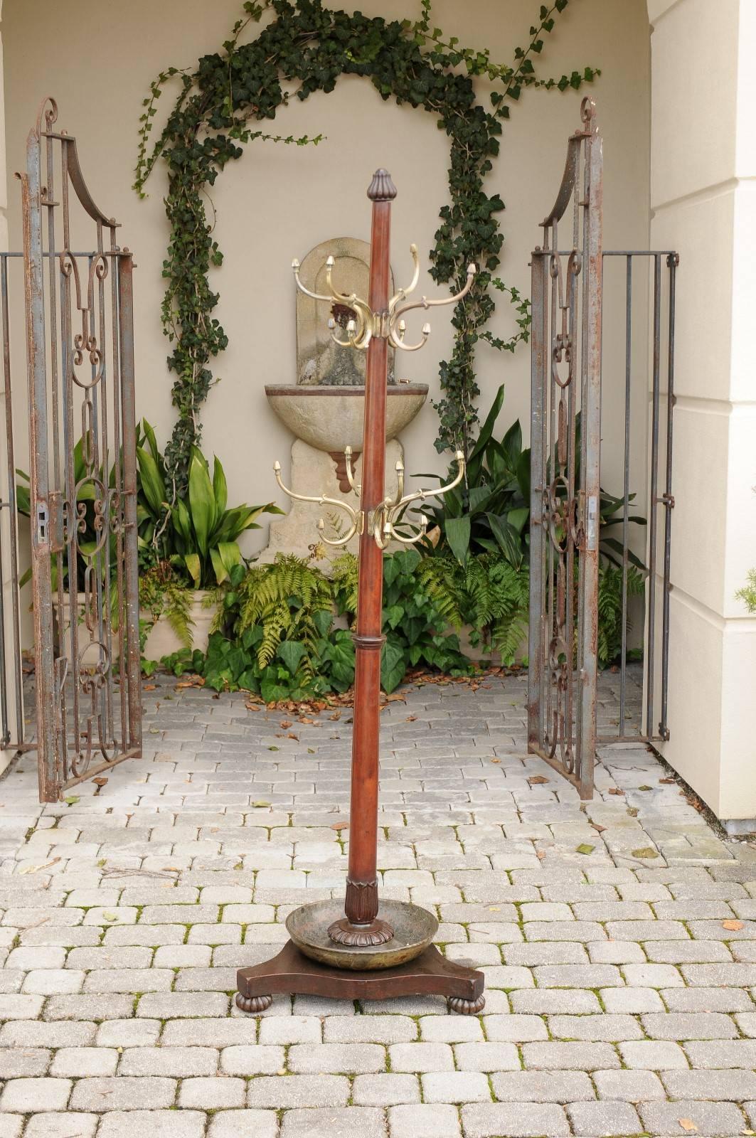 An English period Regency tall mahogany coat rack with bronze hooks from the early 19th century. This English coat rack features a central cylindrical mahogany column adorned in its extremities with gadroons and palmette motifs, typical of the taste