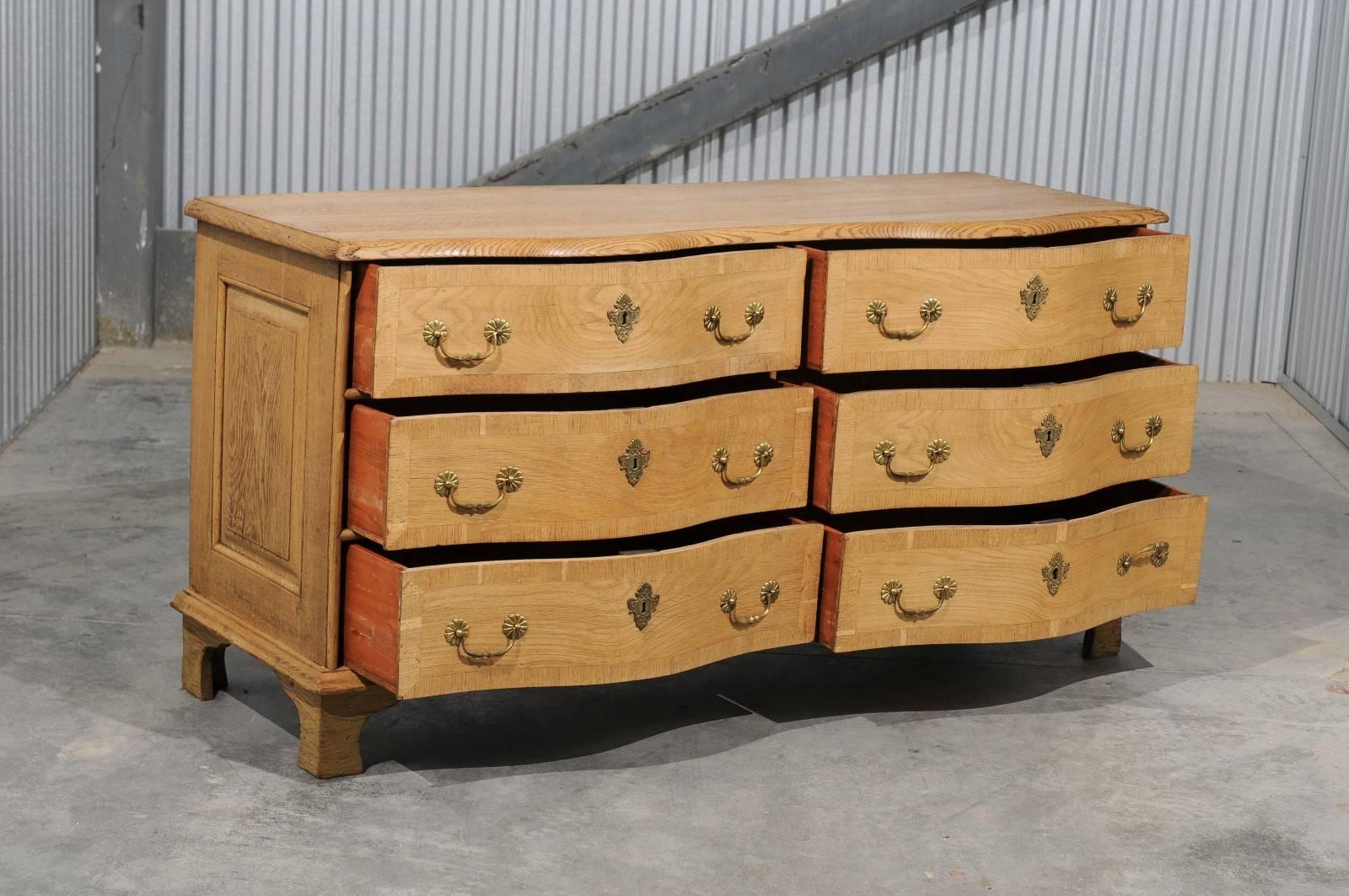 A Swedish bleached wood dresser with serpentine front and double side of drawers from the mid-19th century. This Swedish long chest features a shaped top with beveled edges over a serpentine front made of six drawers. Separated by a series of wooden
