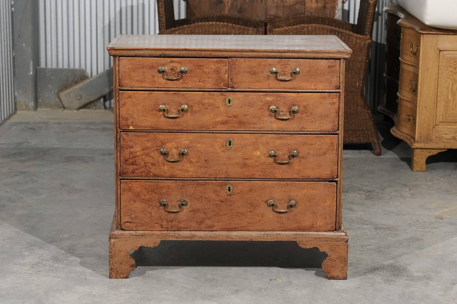 An English George III period four-drawer painted wood chest with bracket feet from the early 1800s. This English Georgian chest features a rectangular top sitting above two small drawers. Three larger graduated drawers make up the rest of the