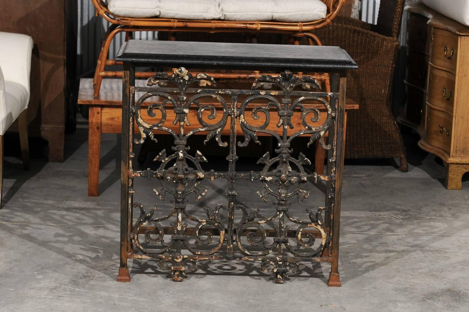 A vintage French wrought iron and stone top console table from the mid-20th century. This French console table features a rectangular black stone top with beveled edges over an exquisite wrought iron base. Typical of the French tradition and