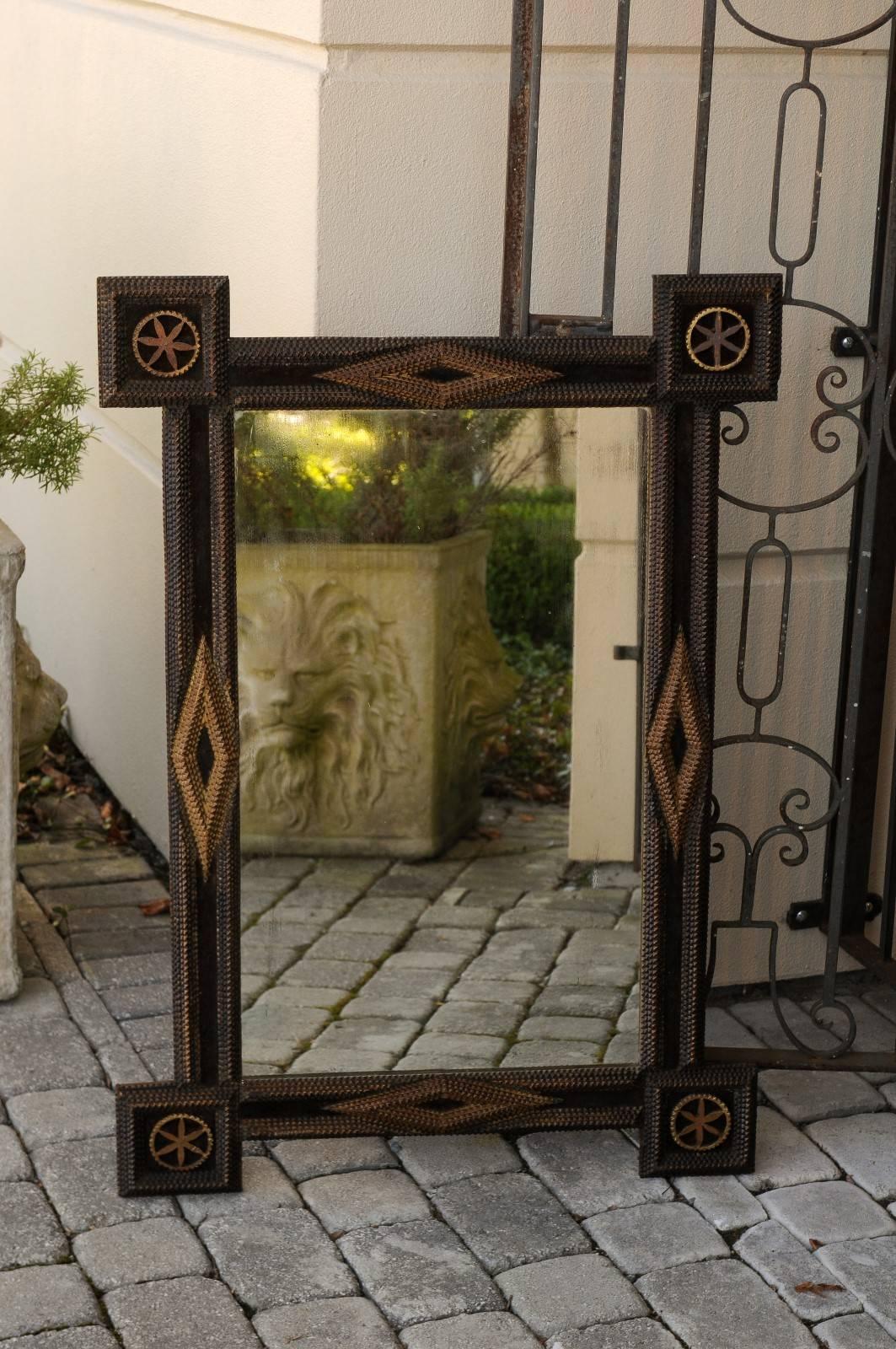 A French turn of the century Tramp Art mirror with flower shaped carved medallions. This French mirror was created in the early years of the 20th century in the manner typical of the Tramp Art style: hand-carved with overlapping notches, the