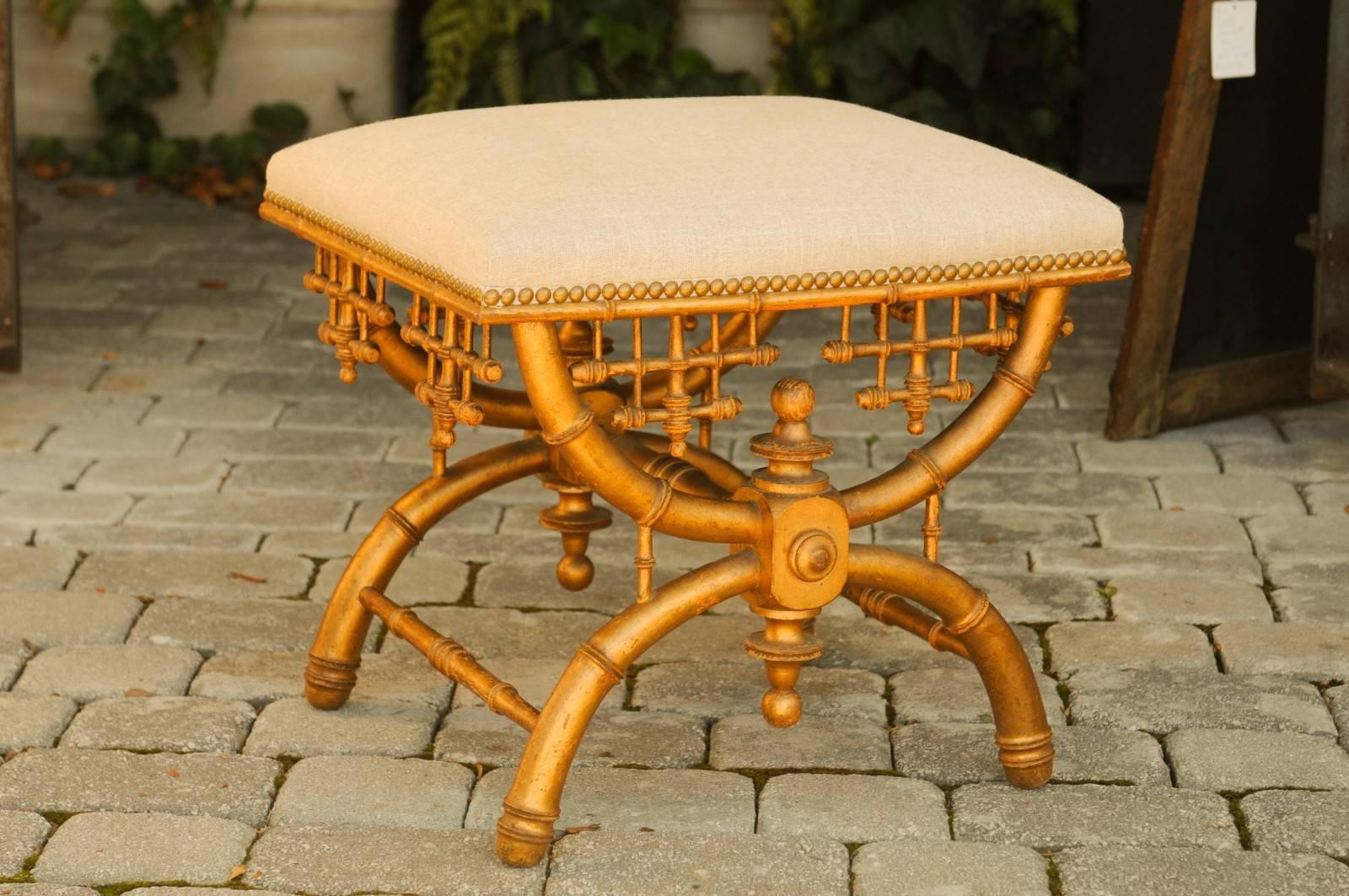 An English Brighton Pavilion style chinoiserie giltwood stool from the mid-20th century. This English stool features a Chinese Chippendale giltwood frame, made in the manner of Brighton Pavilion. The rectangular seat, covered in linen upholstery