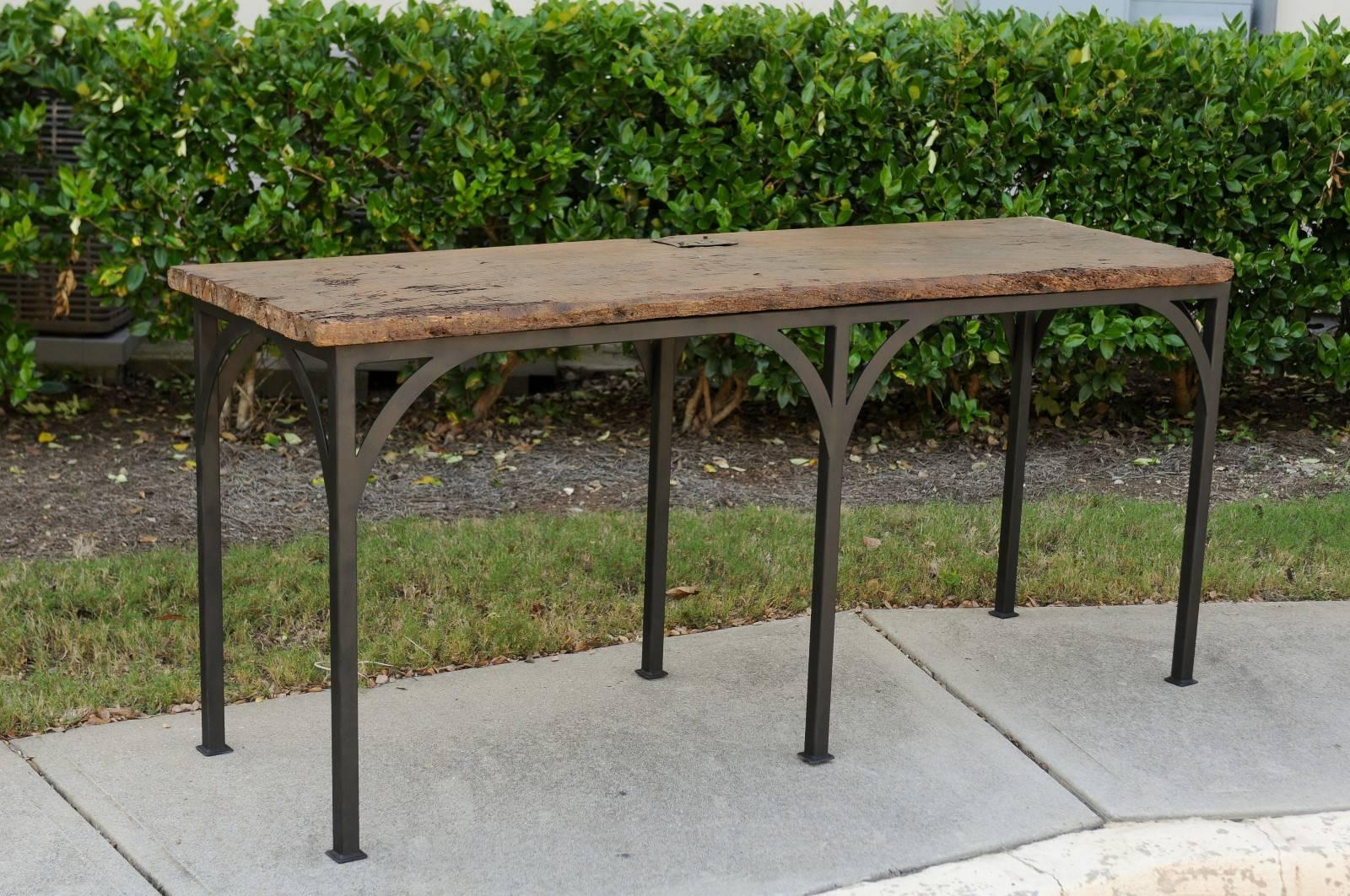 A contemporary rustic console table made of an 18th century Spanish chestnut board mounted on a custom iron base. This handsome console table features a rectangular top made of a nicely weathered chestnut board, secured on custom iron base. This