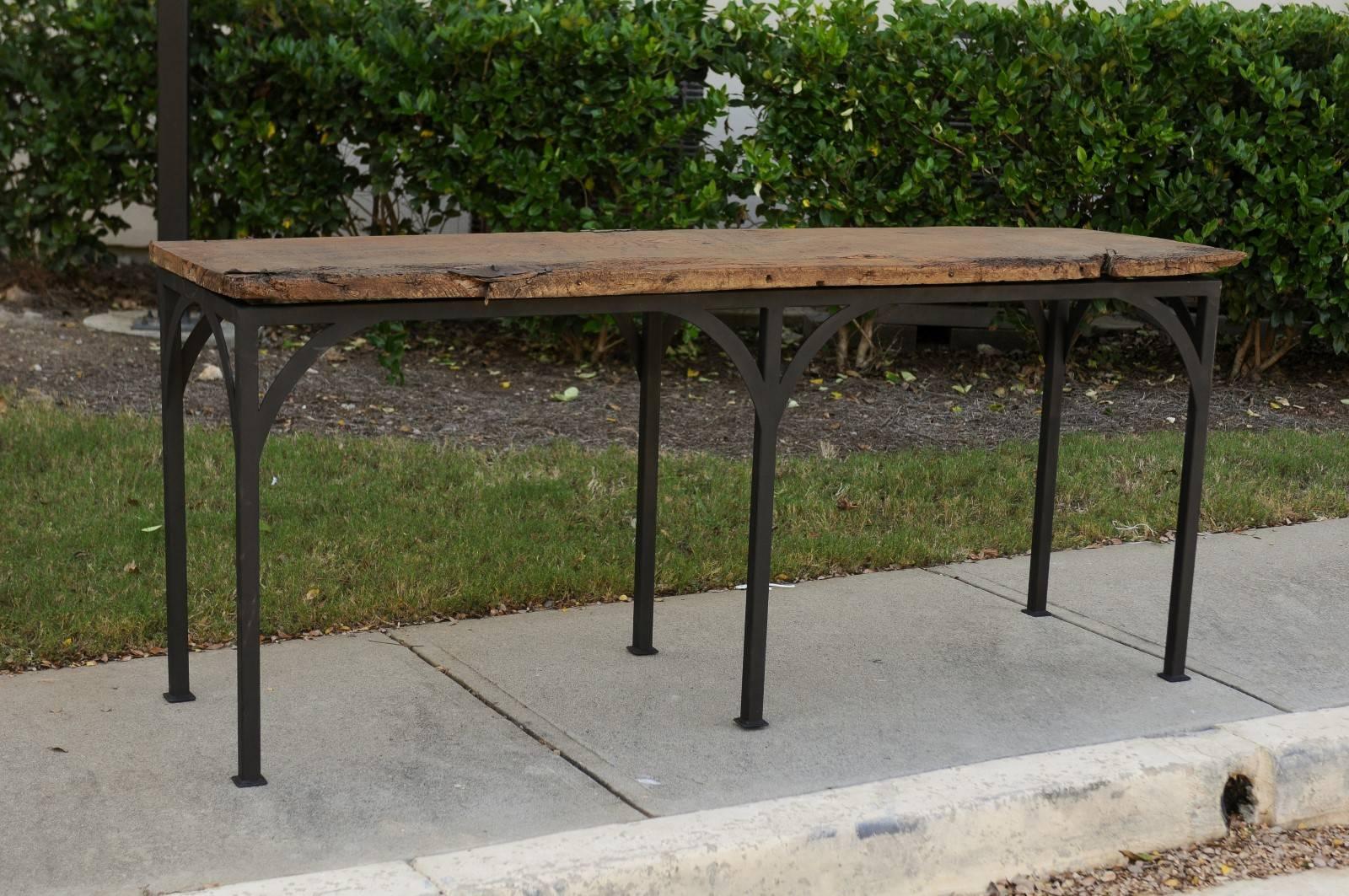 A contemporary console table made of an 18th century Spanish chestnut board mounted on a custom iron base. This console table features a rectangular top made of a nicely weathered chestnut board, secured on custom iron base. This base is made of six