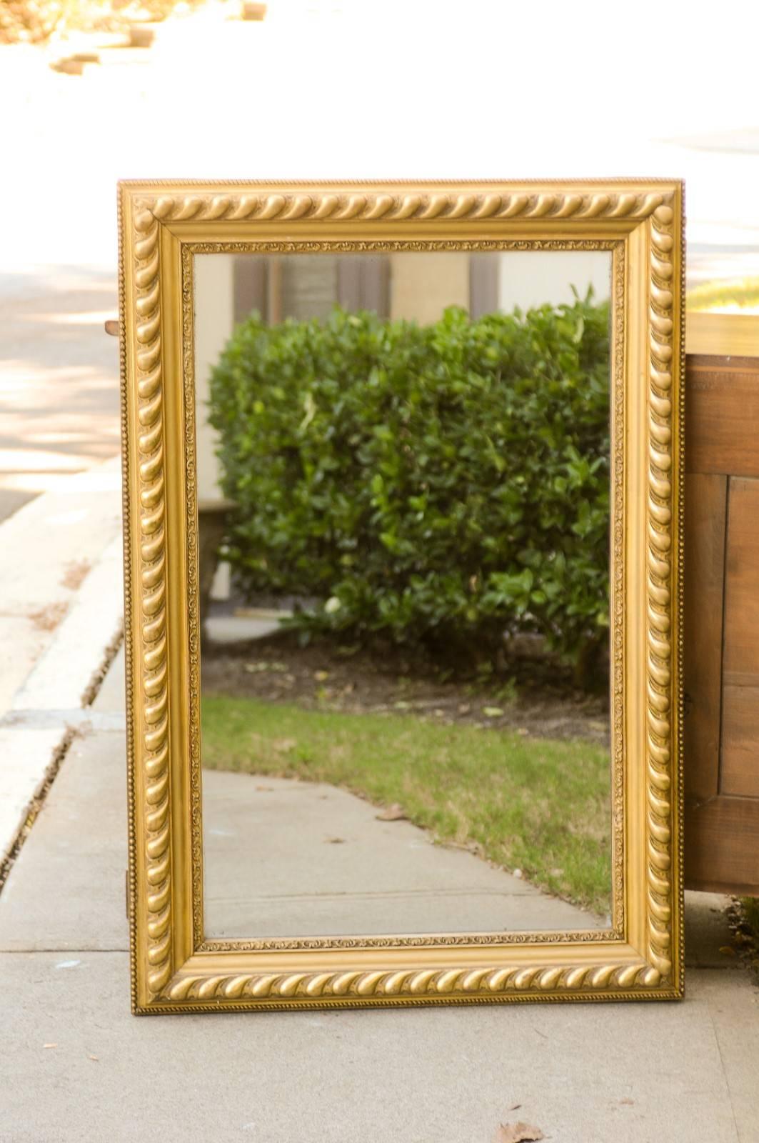 Miroir rectangulaire en bois doré français avec godrons du début du 20e siècle. Ce miroir français présente un cadre rectangulaire, orné d'une belle variété de moulures, des petites perles aux cordes et aux grands godrons. Le cadre intérieur, qui